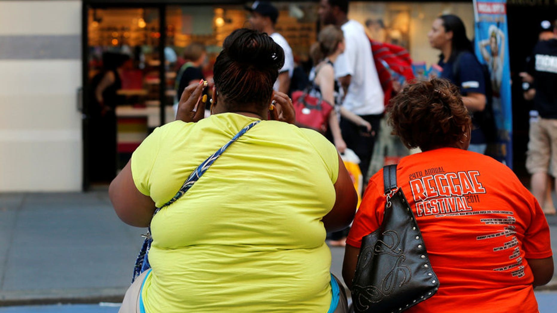 FILE PHOTO: Women sit on bench in Times Square, New York