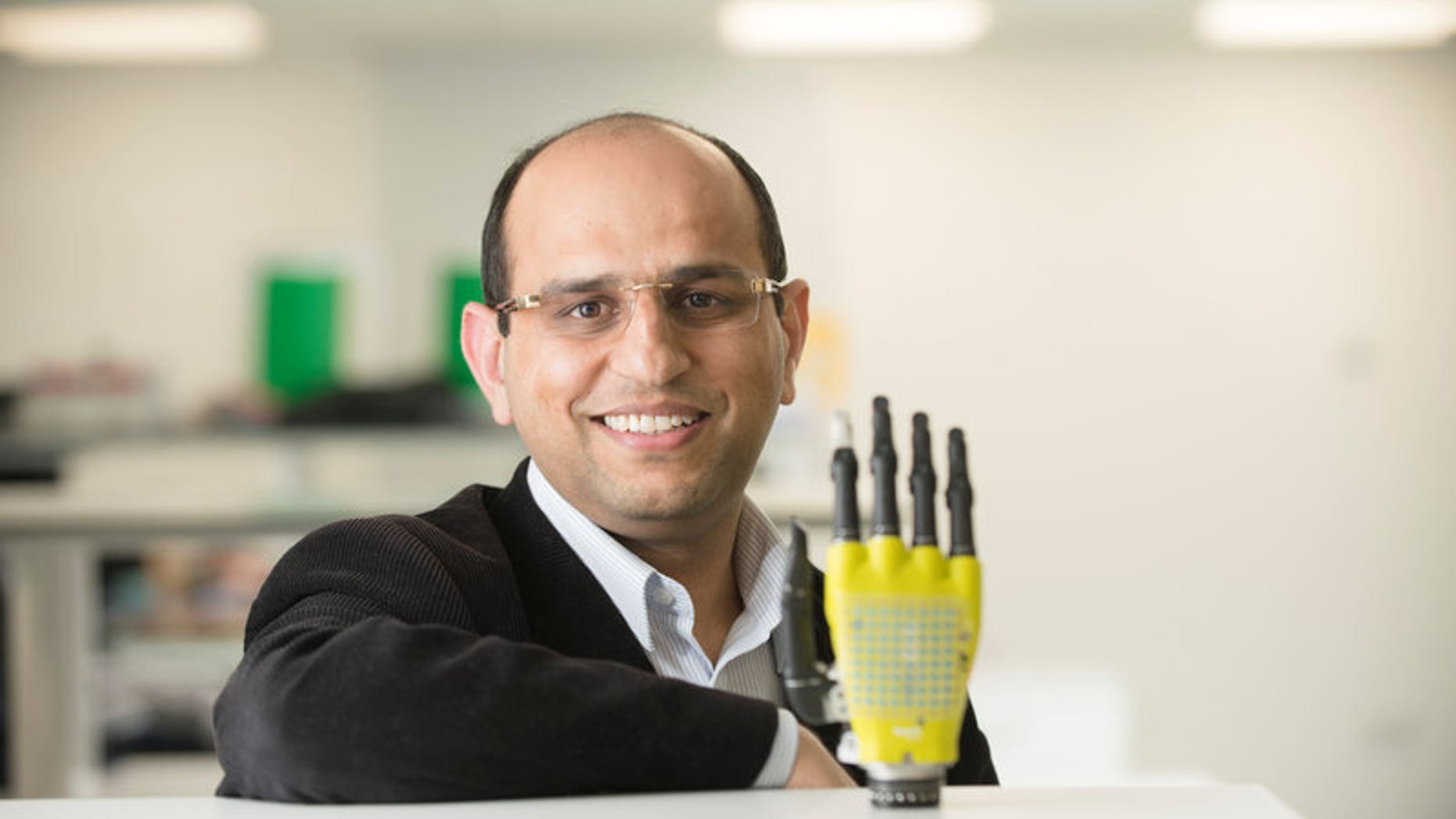 Ravinder Dahiya of the University of Glasgow's School of Engineering poses with the prosthetic hand developed by his team at Glasgow University, Scotland