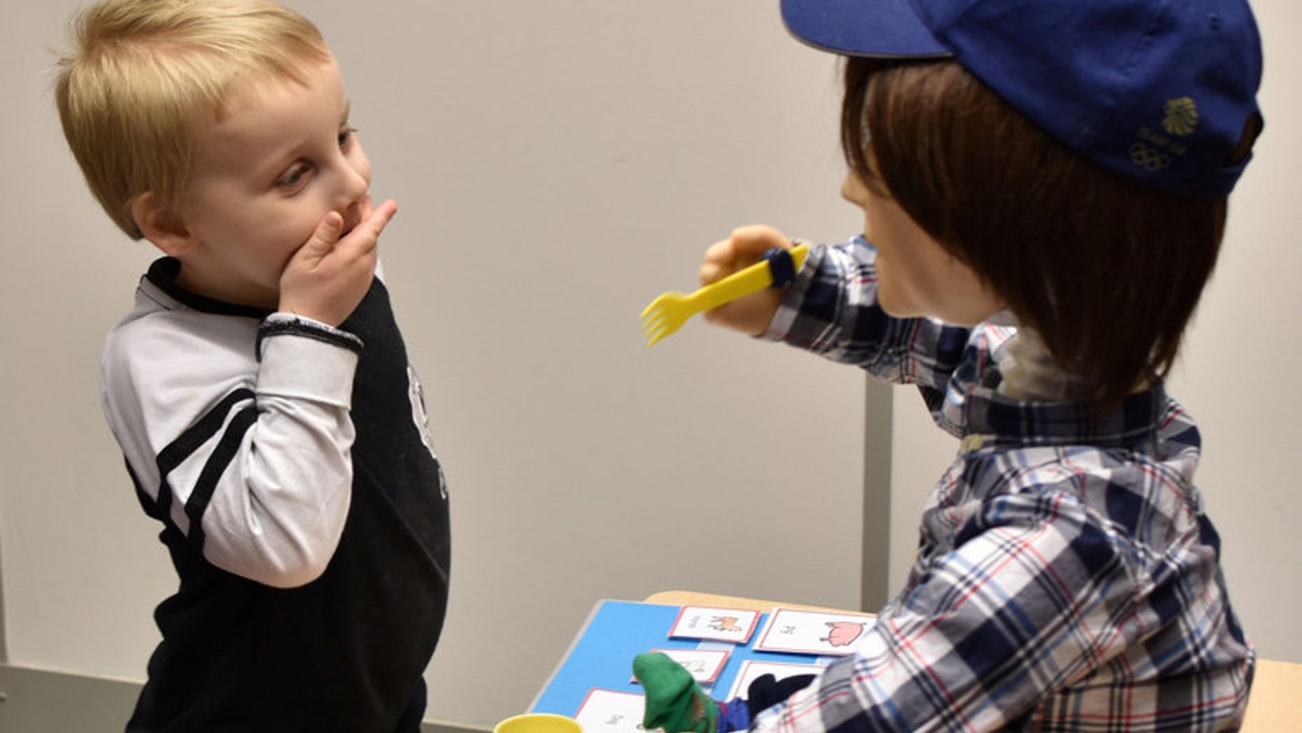 Harrison, 5, who is autistic, plays with Kaspar, a child-sized humanoid robot developed at the University of Hertfordshire.