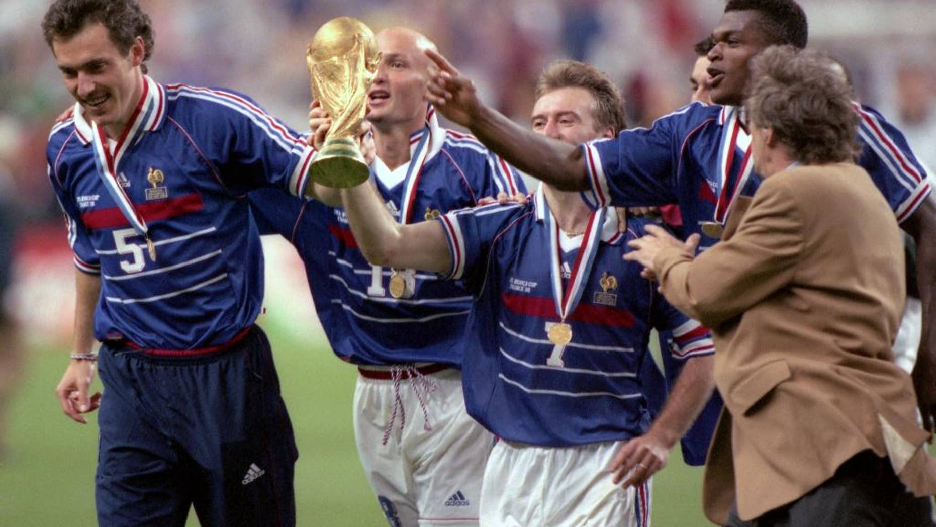 FILE - In this July 12, 1998 filer, Didier Deschamps, center, celebrates on the pitch with the world cup after defeating Brazil in the World Cup Final, in Stade de France, in Saint-Denis, Paris. (AP Photo/ Eric Draper, File)