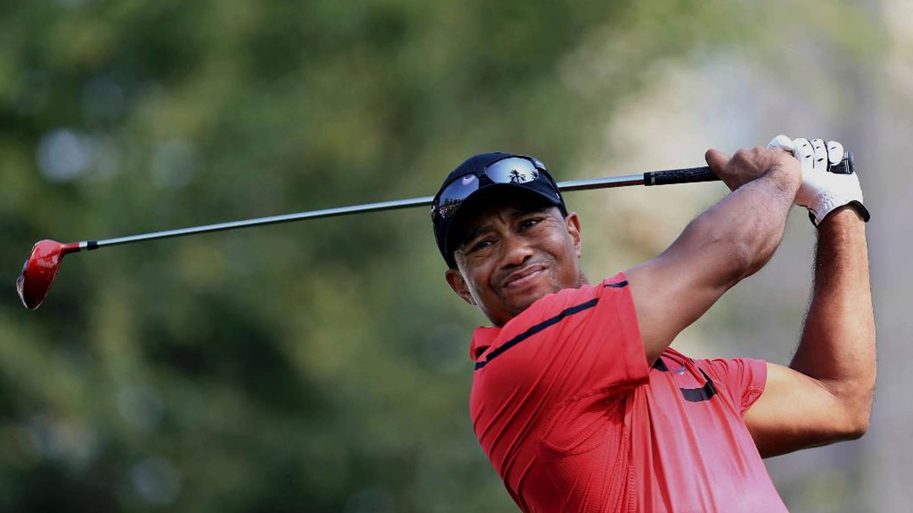 FILE - In this Feb. 2, 2014 file photo, Tiger Woods tees off at the 14th hole during the final round of the Dubai Desert Classic golf tournament in Dubai, United Arab Emirates. Woods is looking to old friend Roger Federer for some inspiration. The 40-year-old American hasn't won a major since 2008, while the 35-year-old Federer claimed his 18th Grand Slam title on Sunday, Jan. 29, 2017, at the Australian Open, beating Rafael Nadal in the final in his first tournament following a six-month injury layoff. (AP Photo)