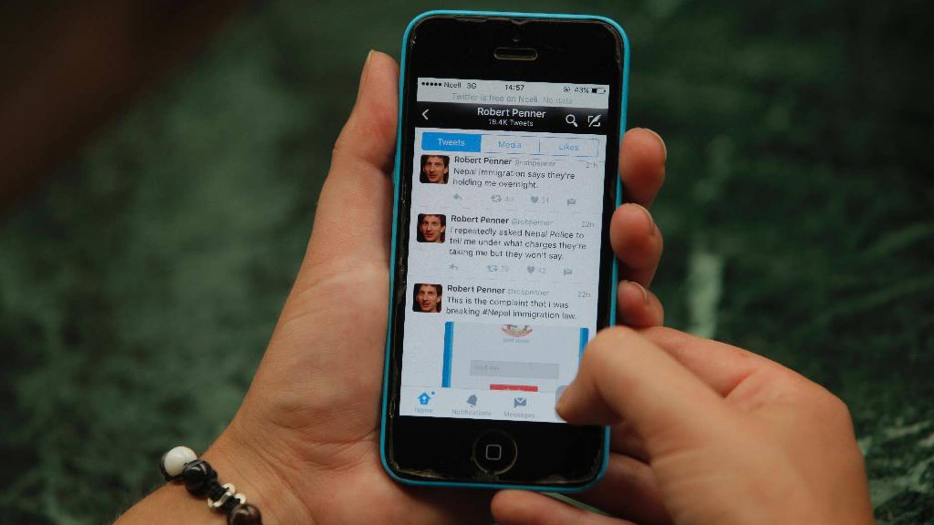 Twitter page of Canadian man, Robert Penner is seen on the screen of a mobile phone in Kathmandu, Nepal, Tuesday, May 3, 2016. Nepalese officials say they have ordered Penner to leave the country within two days for posting messages on social media that could disturb social harmony. (AP Photo/Niranjan Shrestha)