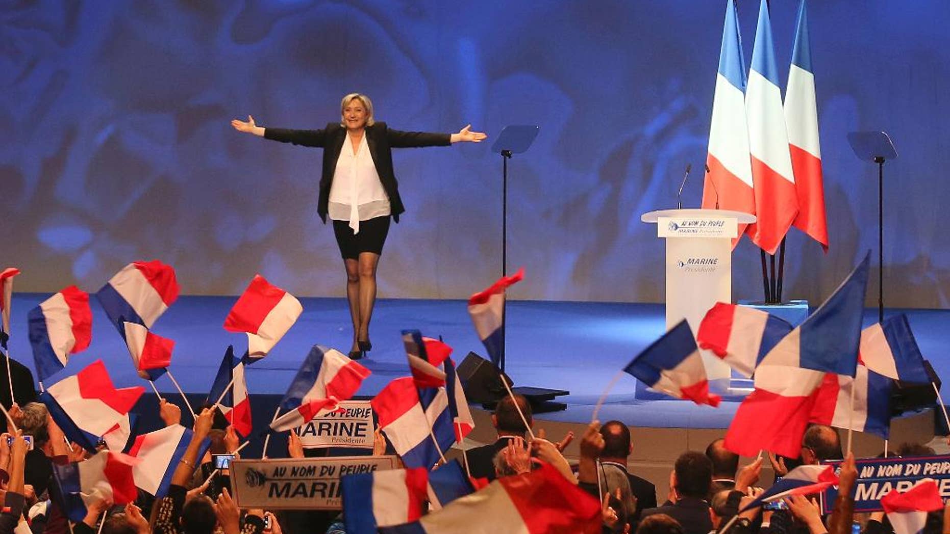 FILE - In this Feb. 26, 2017 file photo, French far-right leader presidential candidate Marine Le Pen gestures at the start of a meeting in Nantes, western France. Marine Le Pen, whose passion for politics and far-right values were forged in the cradle, is making her second bid for the French presidency, hoping this time to break through the ceiling of fear that stopped her father from winning in 2002. (AP Photo/David Vincent, File)