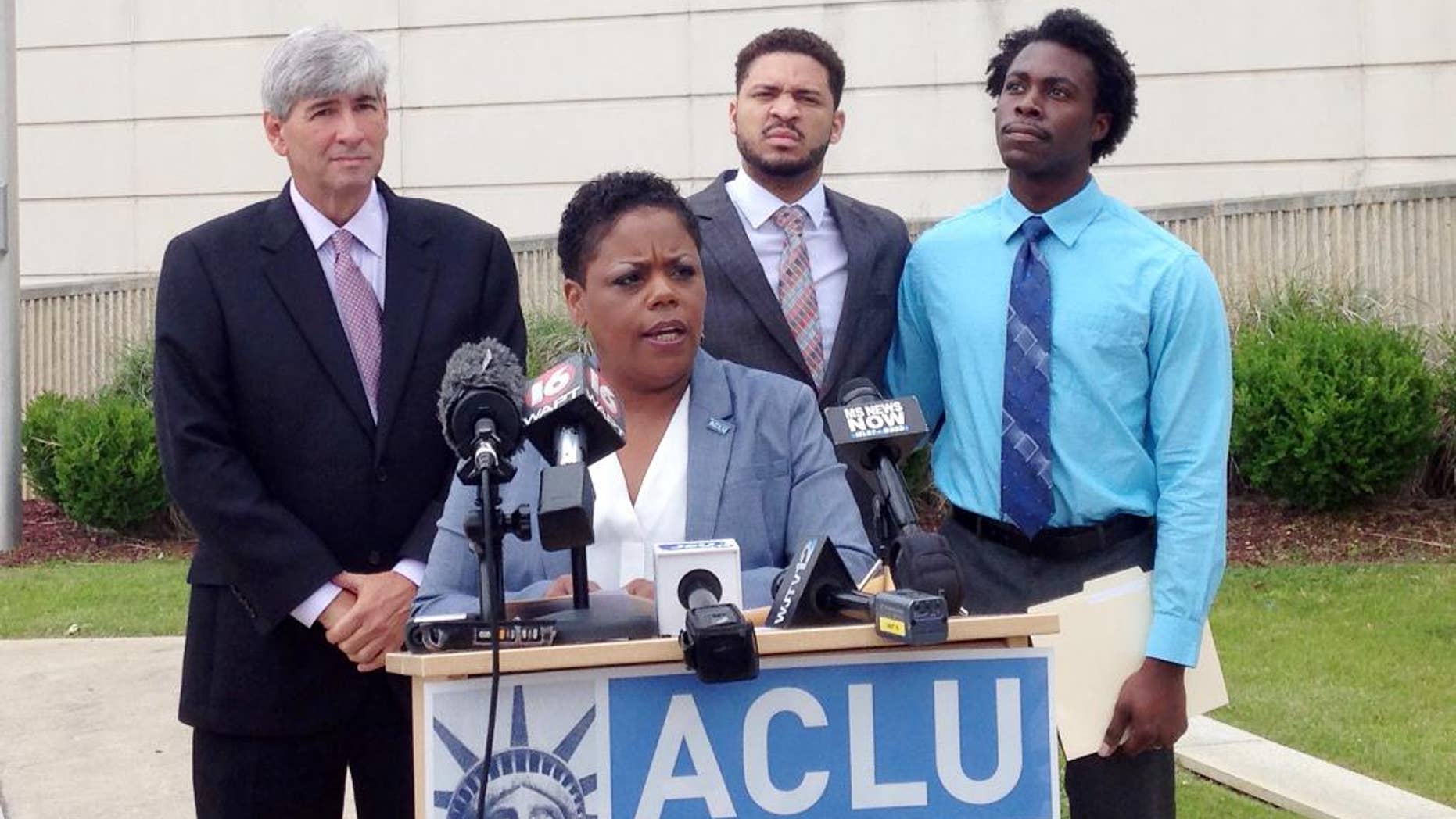 Jennifer Riley-Collins, executive director of the American Civil Liberties Union of Mississippi, center, speaks Monday, May 9, 2016, in Jackson, Miss., about a lawsuit the group filed against the state over House Bill 1523, which will allow workers to cite their own religious objections to same-sex marriage and deny services to citizens. Behind Riley-Collins are attorney Oliver Diaz, left, and plaintiffs in the lawsuit, Nykolas Alford and Stephen Thomas. Alford and Thomas, of Meridian, Miss., are engaged. The lawsuit asks a federal judge to declare that House Bill 1523 violates the equal-protection guarantee of the 14th Amendment and to block the state from enforcing the measure, which is set to become law July 1. (AP Photo/Emily Wagster Pettus)