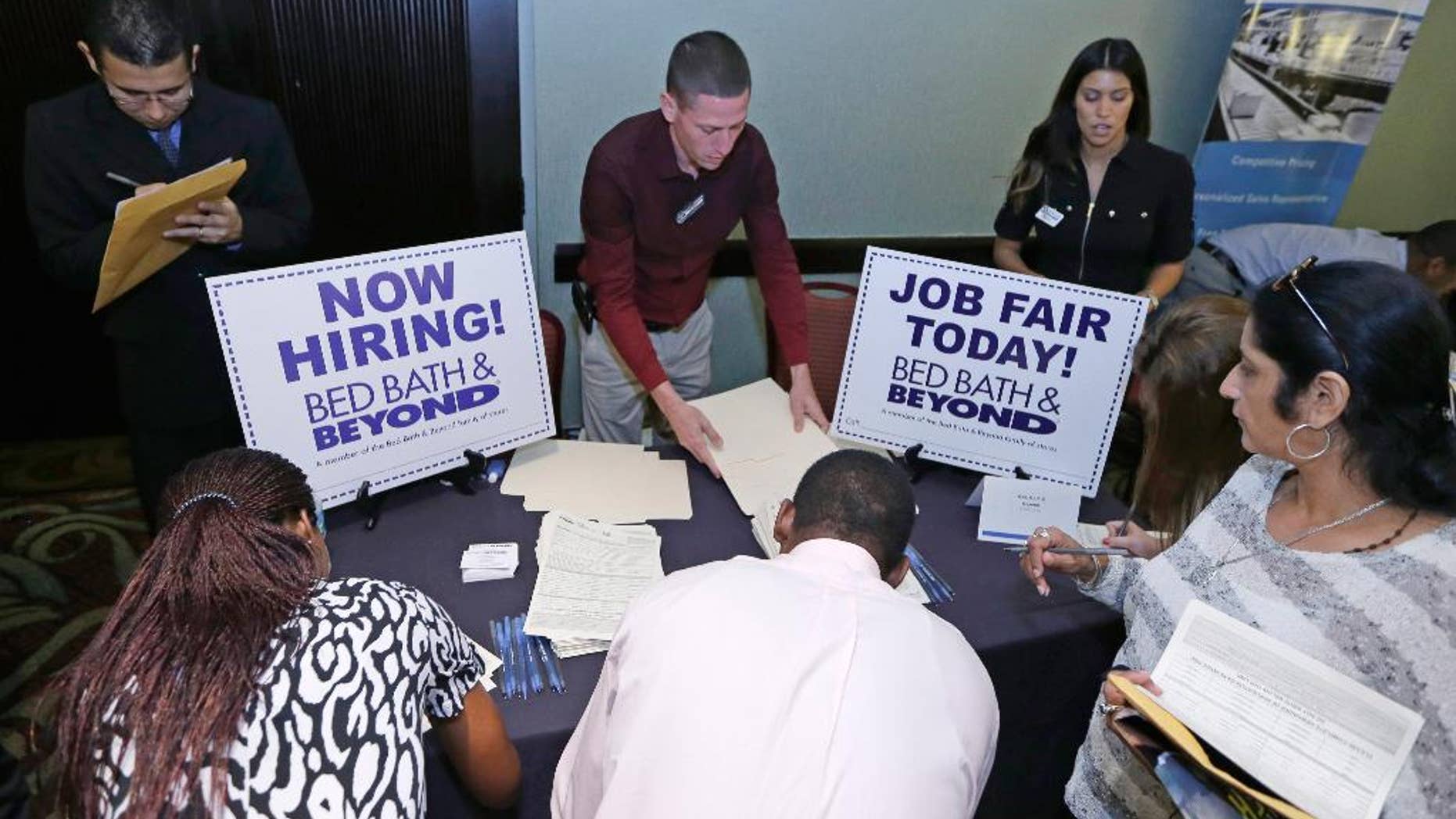 FILE - In this Oct. 22, 2014 file photo, job seekers fill out a job applications at a job fair in Miami Lakes, Fla. The Labor Department reports on state unemployment rates for April on Wednesday, May 27, 2015. (AP Photo/Alan Diaz, File)