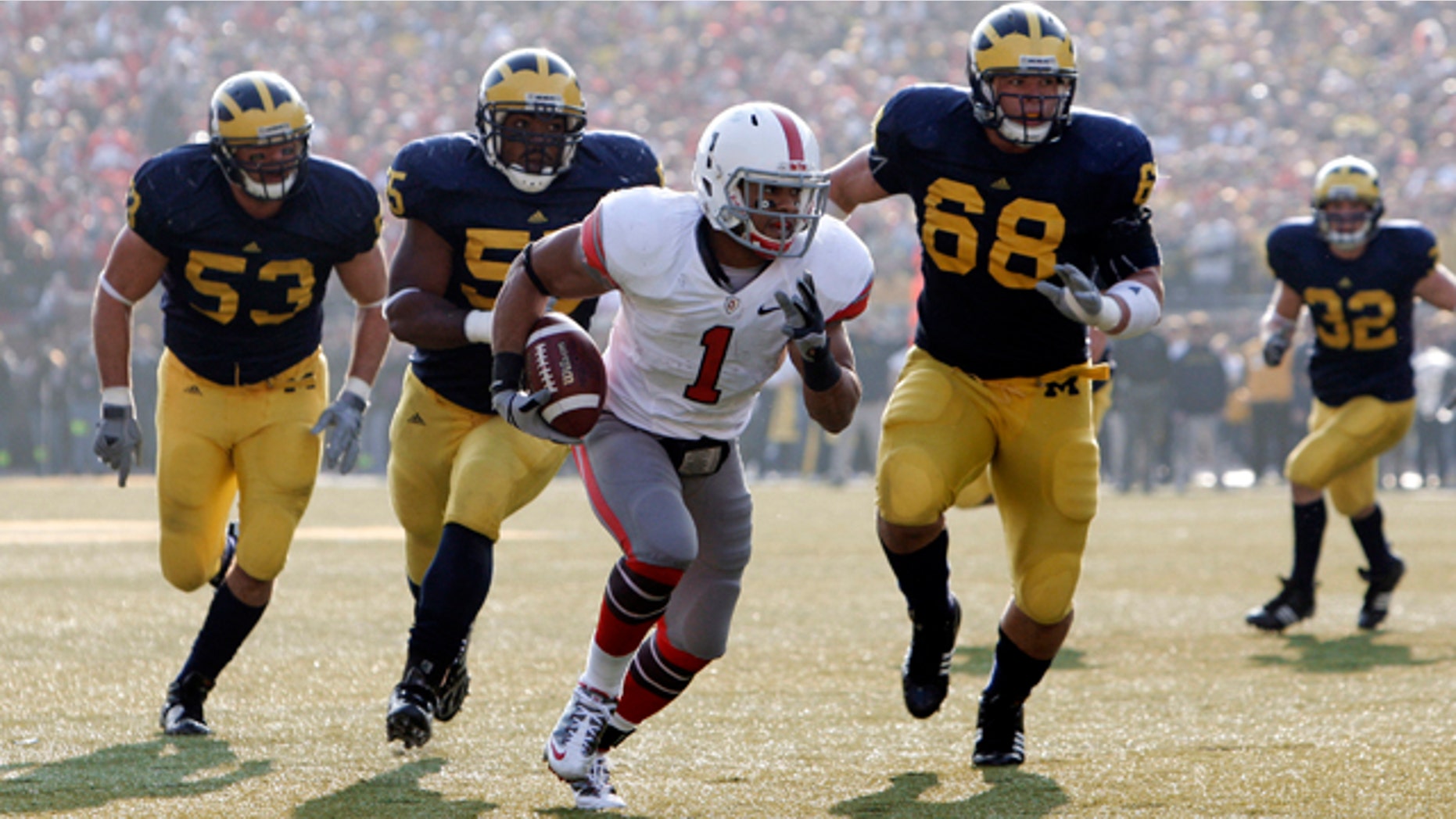 FILE - In this Nov. 21, 2009 file photo, Ohio State running back Dan Herron (1) scores a touchdown on a 12-yard reception as the Michigan defense chases during the third quarter of an NCAA college football game in Ann Arbor, Mich. So you're the Big Ten or Pac-10 and you're trying to decide how to split your new, 12-team league into two divisions while keeping traditional rivalries intact and avoiding competitive imbalance and geographic oddities. The SEC, ACC and Big 12 have been through this before _ and their experiences may offer a few lessons. (AP Photo/Paul Sancya, File)