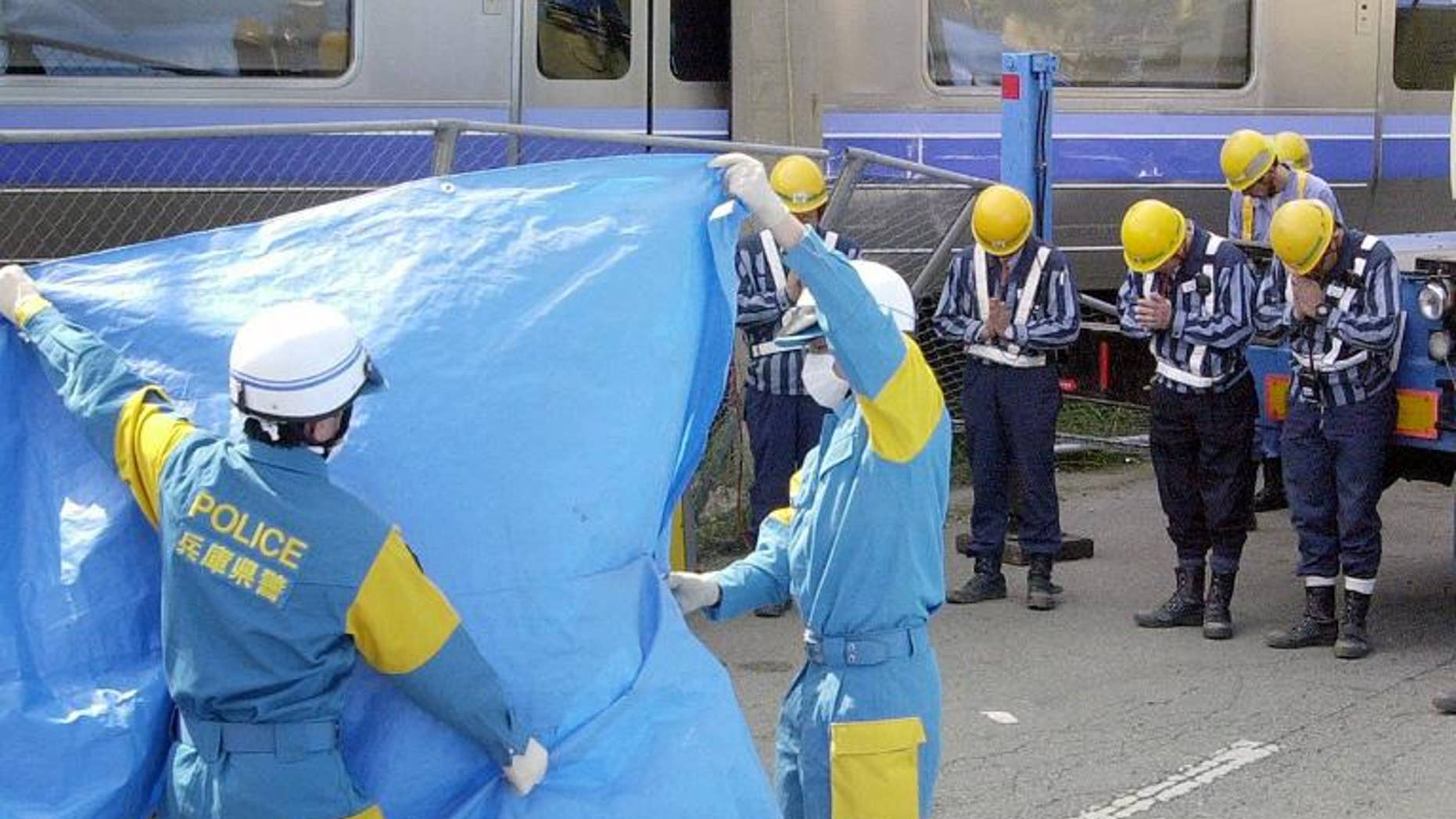 Japan Railway West (JR West) workers offer prayers to a dead body at the site of the train crash in Amagasaki in April 2005. Three former presidents of JR West have been cleared of responsibility for the 2005 train crash that killed over 100 people.