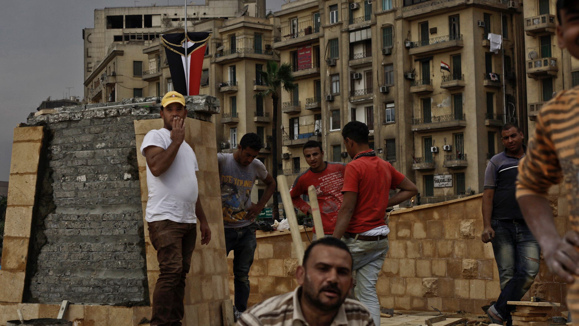 In this Sunday, Nov. 17, 2013 photo, Egyptian municipality laborers work on a memorial base two days before the commemoration of deadly clashes with security forces in 2011, in Tahrir Square, Cairo. Egypt's government wants the memorial to commemorate those killed in protests over two years of unrest in the country, but some say the memorial is just a means to make it appear there's political stability in the Arab world's most populous nation. (AP Photo/Nariman El-Mofty)