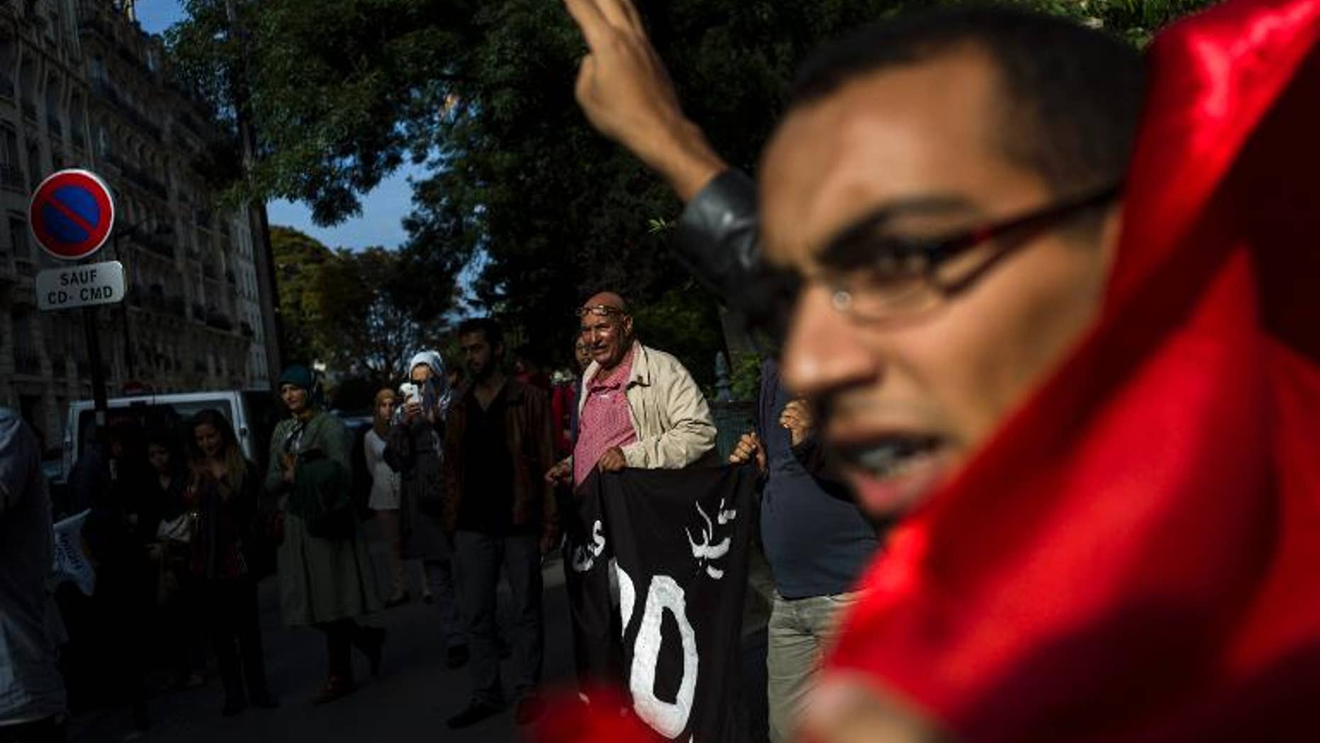 Protesters call for the release of Ali Anouzla, a website editor arrested after he posted an article about a jihadist video, Morocco Embassy, Paris, September 21, 2013. Morocco ambassy, on September 21, 2013 in Paris, to call for the release of The prosecutor who ordered Anouzla's arrest said the video, which was attributed to al-Qaida in the Islamic Maghreb (AQIM), "contained a clear call and direct incitement to perpetrate acts of terrorism in Morocco." AFP PHOTO / FRED DUFOUR