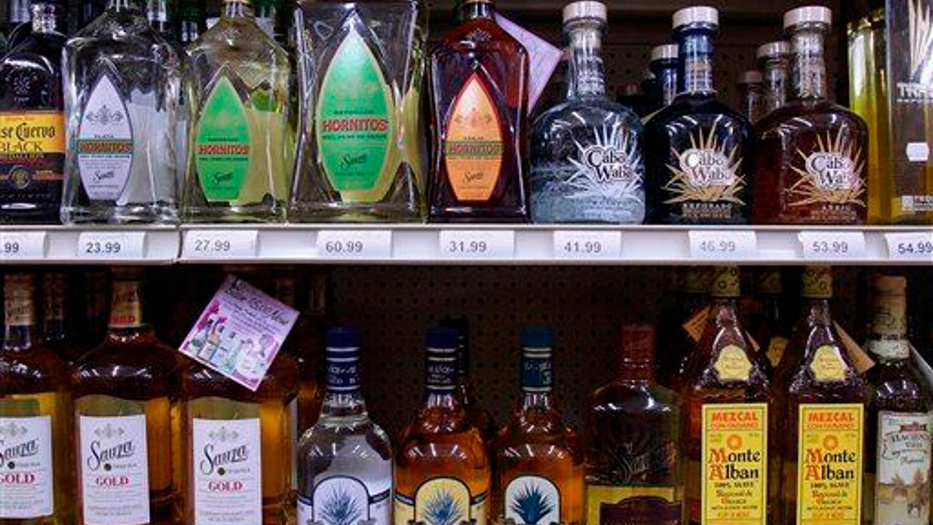 In this Monday, Aug. 31, 2009 file photo, bottles of alcohol are seen lining the shelves of a liquor store in Springfield, Ill. It's the time of year that social host liability laws can leave parents vulnerable for teens drinking under their roofs.