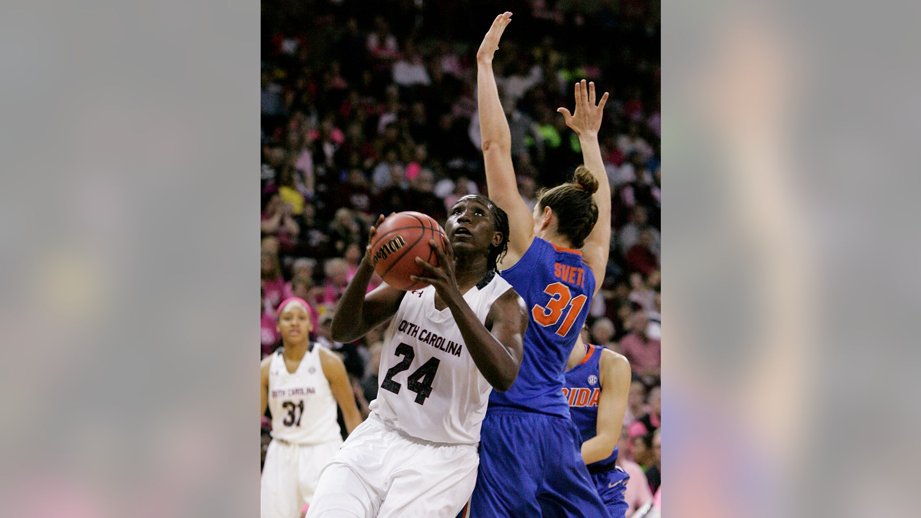 South Carolina's Aleighsa Welch (24) gets past Florida's Lily Svete as she drives for the basket during the second half of their NCAA college basketball game, Sunday, Feb. 23, 2014, in Columbia, SC. (AP Photo/Mary Ann Chastain)