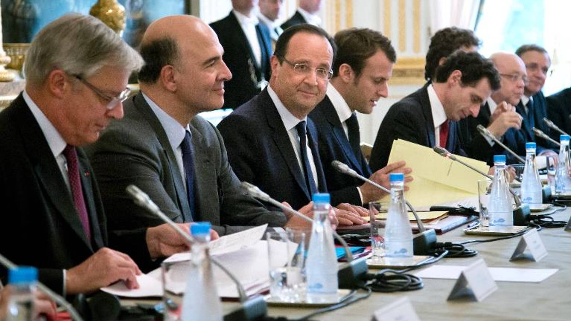 French President Francois Hollande (C) and French Finance Minister Pierre Moscovici (2nd L) attend a meeting with the Board of Governors of the European Central Bank, on October 1, 2013, at the Elysee presidential palace in Paris