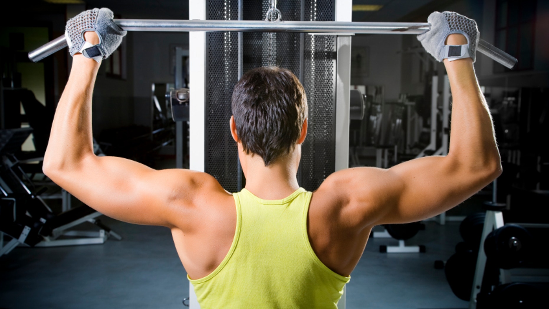 health club: man in a gym doing weight lifting