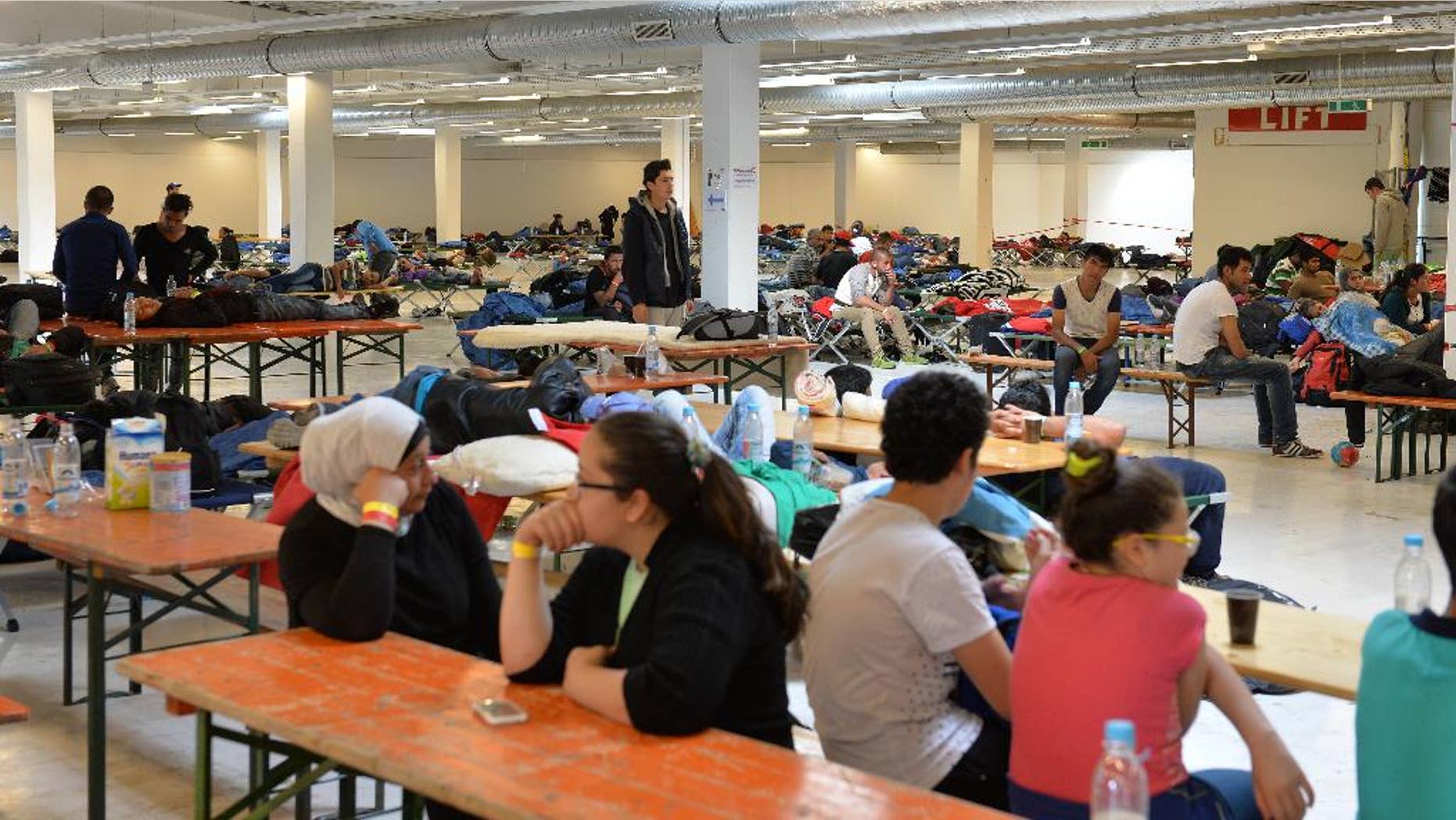 Refugees rest in a former furniture factory after crossing the border from Austria in Freilassing, southern Germany, Thursday, Sept. 17, 2015. (AP Photo/Kerstin Joensson)