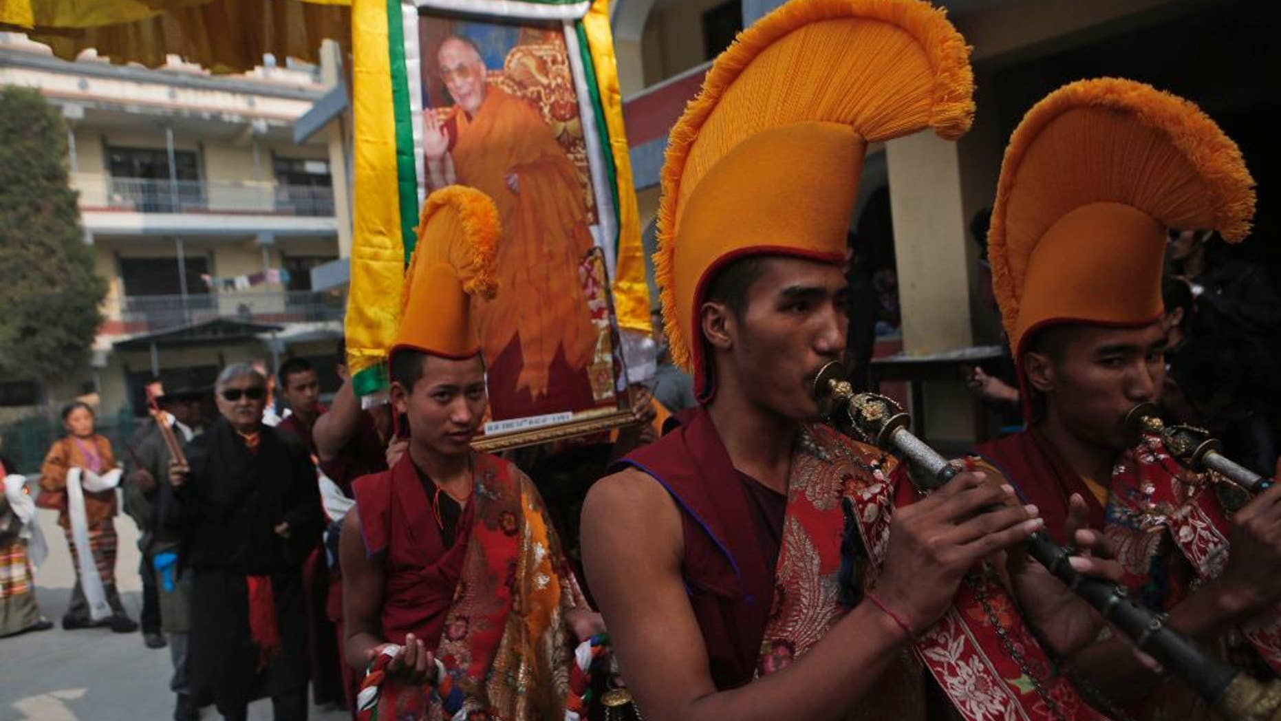 Tibetan monks carry a portrait of their spiritual leader the Dalai Lama and play traditional instruments during a special prayer ceremony on the third day of the Tibetan New Year celebrations in Kathmandu, Nepal, Wednesday, March 1, 2017. (AP Photo/Niranjan Shrestha)