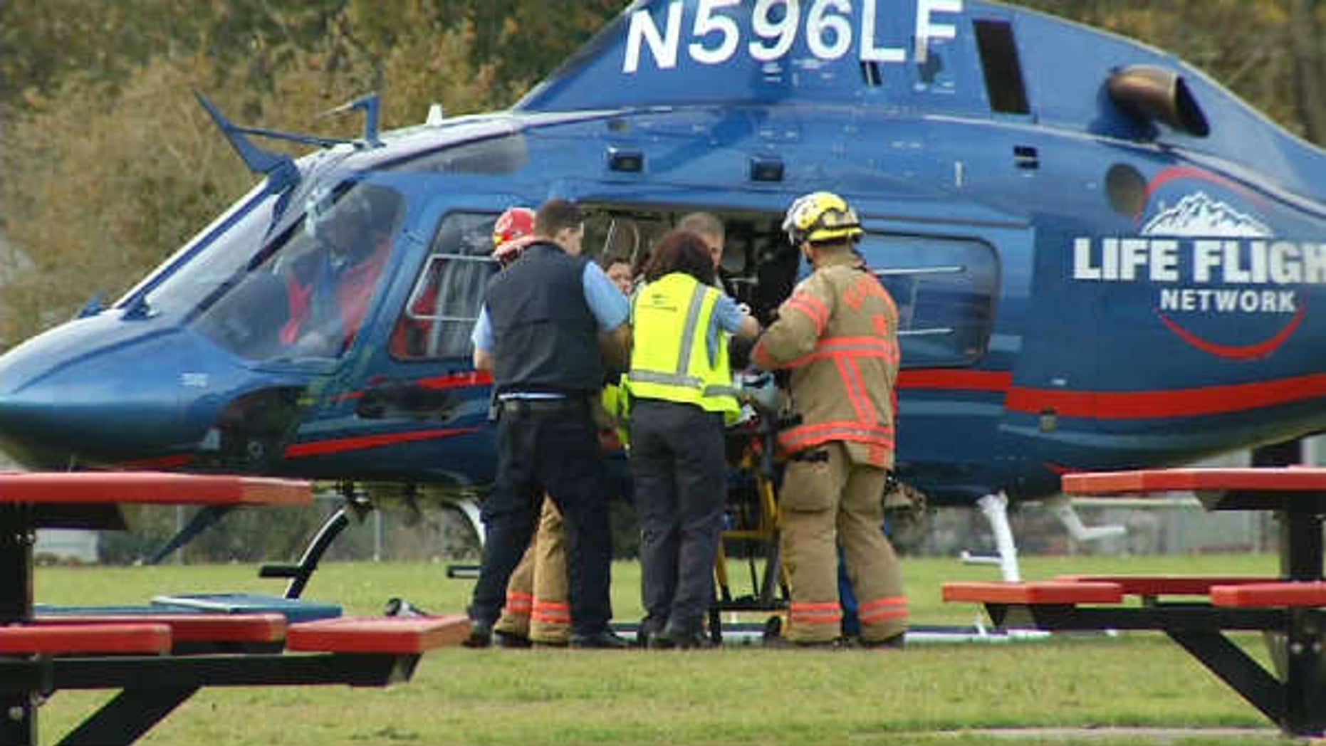 November 3, 2013: A police officer is loaded onto a helicopter after being shot responding to a fire in Oregon City, Ore. (Courtesy KPTV)