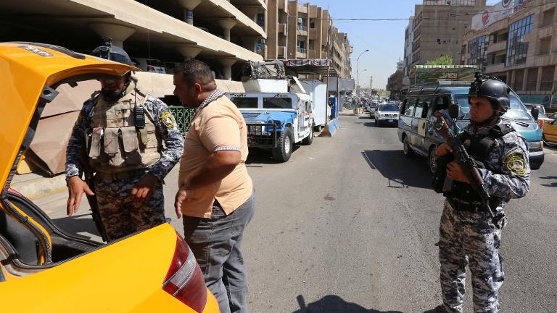Iraqi security forces search a taxi cab at a mobile checkpoint in Baghdad on August 27, 2013. Car bombs mainly targeting Shiite-majority areas of Baghdad province killed at least 25 people and wounded more than 100 on Monday.