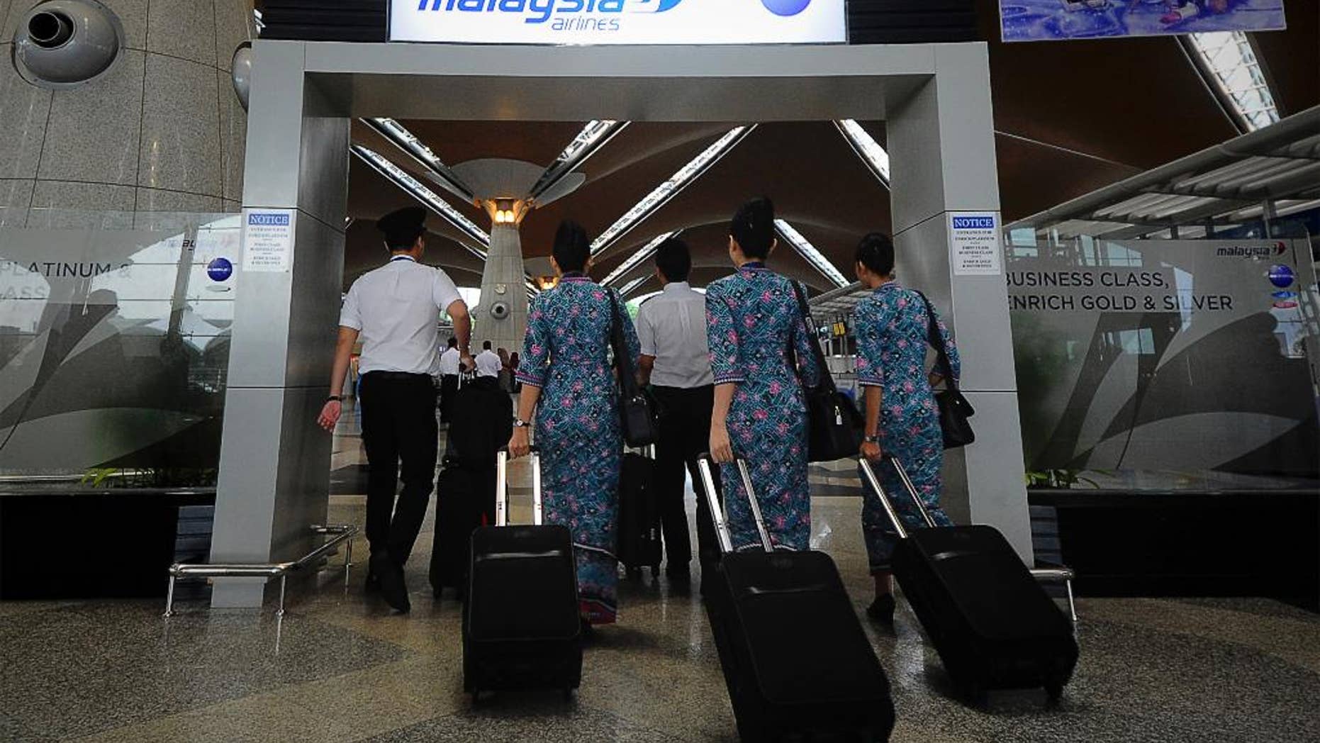 FILE - In this April 10, 2014, file photo, a Malaysia Airlines crew walks into a check in area at Kuala Lumpur International Airport in Sepang, Malaysia. New Malaysia Airlines CEO, Christoph Mueller, 52, comes to the post fresh from a stint reviving Ireland’s Aer Lingus. Mueller will be the first foreigner to head the Malaysian state-owned company. Analysts say he’s an industry veteran “battle hardened” from his work carrying out corporate restructurings at other state-owned airlines, including failed Belgian carrier Sabena. (AP Photo/Joshua Paul, File)