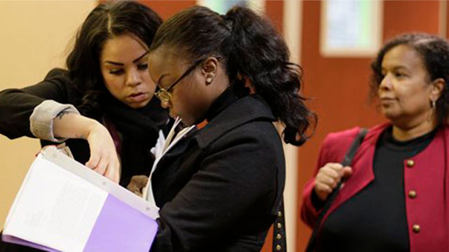 Jan. 28, 2012: Job seekers Cameo Taylor, left, and Angelique McGuire, center, both of San Francisco, wait in line to register at a Career Fair event in San Francisco.