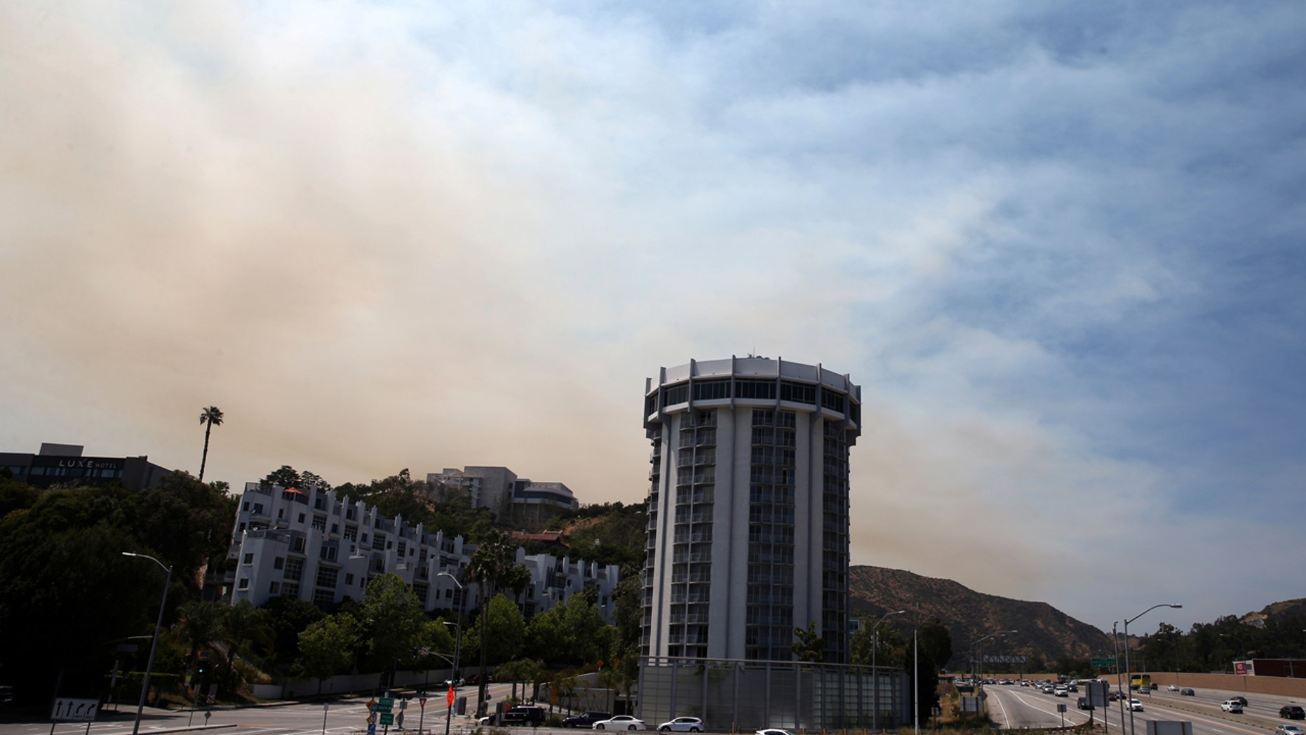 FILE: A wildfire burns behind Getty Center in Mandeville Canyon in Los Angeles