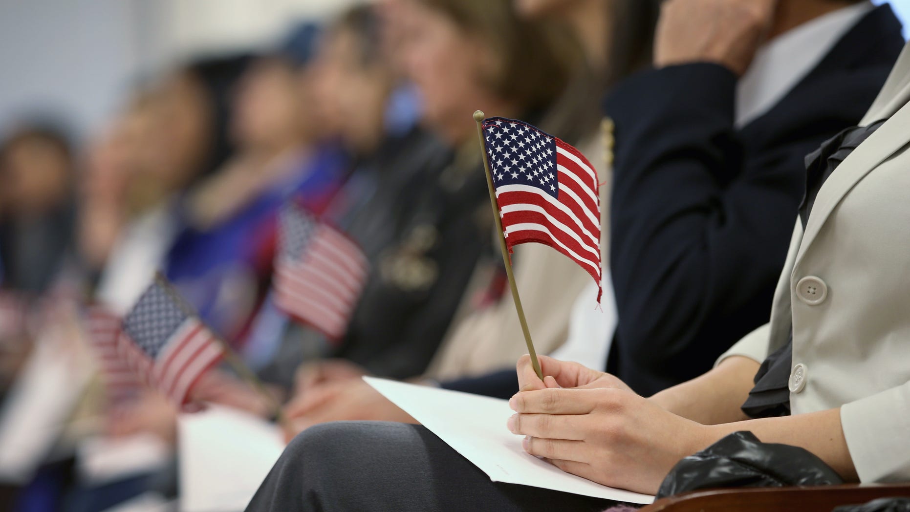 NEWARK, NJ - JANUARY 28: Immigrants hold flags while waiting for a naturalization ceremony to become U.S. citizens at the district office of U.S. Citizenship and Immigration Services (USCIS) on January 28, 2013 in Newark, New Jersey. Some 38,000 immigrants became U.S. citizens at the Newark office alone in 2012. (Photo by John Moore/Getty Images)