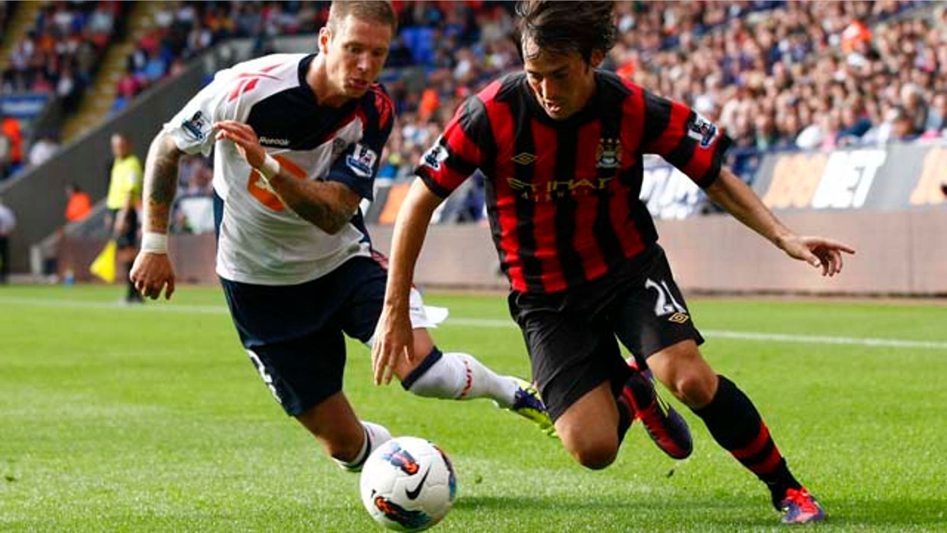 Manchester City's David Silva, right, vies for the ball against Bolton's Gretar Steinsson during their English Premier League soccer match at the Reebok Stadium, Bolton, England, Sunday Aug. 21, 2011. (AP Photo/Tim Hales)