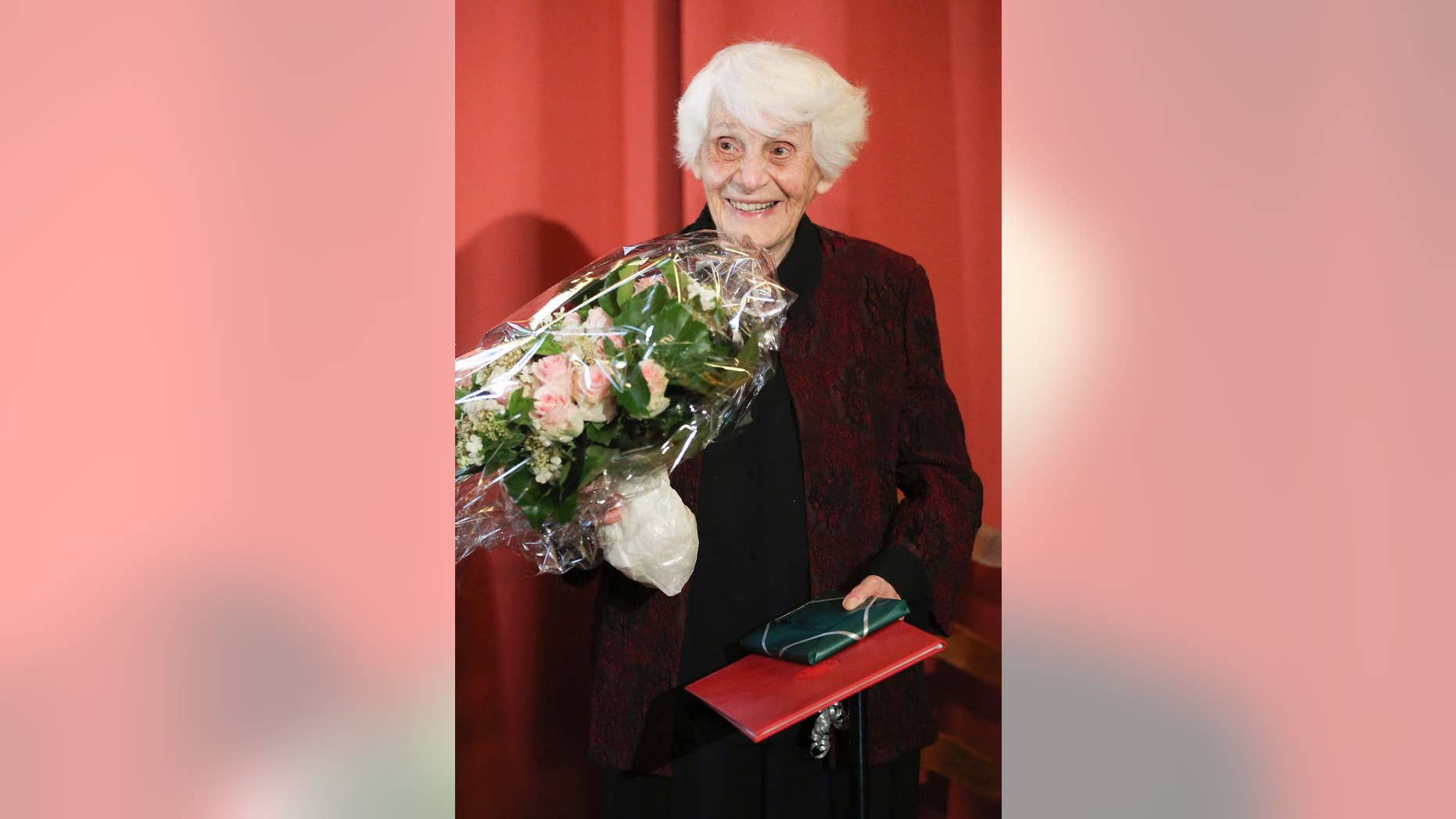 FILE - In this June 9, 2015 file photo Ingeborg Syllm-Rapoport holds her doctoral certificate and a bunch of flowers during a ceremony at the University Clinic Hamburg-Eppendorf in Hamburg, Germany. Syllm-Rapoport wasn't allowed to defend her doctoral thesis in 1938 under the Nazis because she was part-Jewish. 77 years later, she had completed all the requirements and became Germany's oldest recipient of a doctorate at age 102. Syllm-Rapoport died March 23, 2017. She was 104. (Bodo Marks/dpa via AP, file)