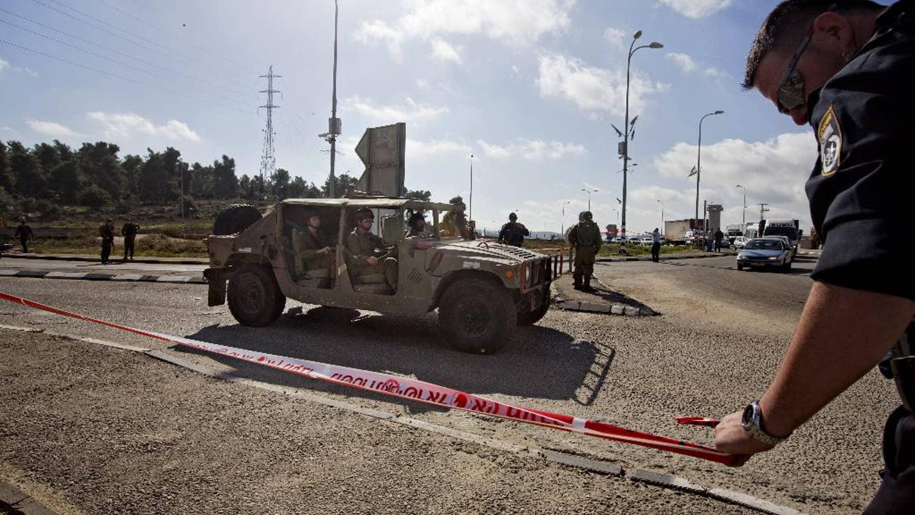 Dec. 1, 2014 - Israeli soldiers and police officers stand at the scene of a stabbing attack at the West Bank Gush Etzion junction near Jerusalem. A Palestinian woman stabbed and slightly wounded an Israeli civilian in the West Bank, the Israeli military said. Eyewitnesses said the attacker involved was shot by security forces in the area and taken for medical treatment.