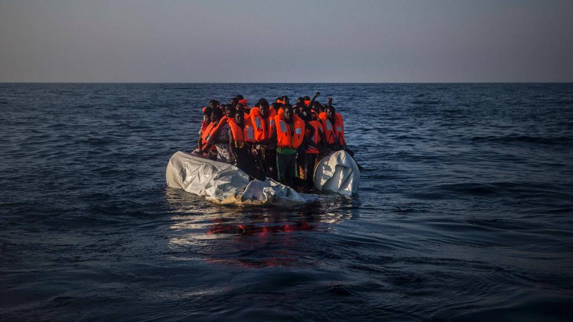 In this photo taken on Saturday Sept. 10, 2016, African refugees and migrants wait aboard a partially punctured rubber boat to be assisted, during a rescue operation on the Mediterranean Sea, about 13 miles North of Sabratha, Libya. (AP Photo/Santi Palacios)