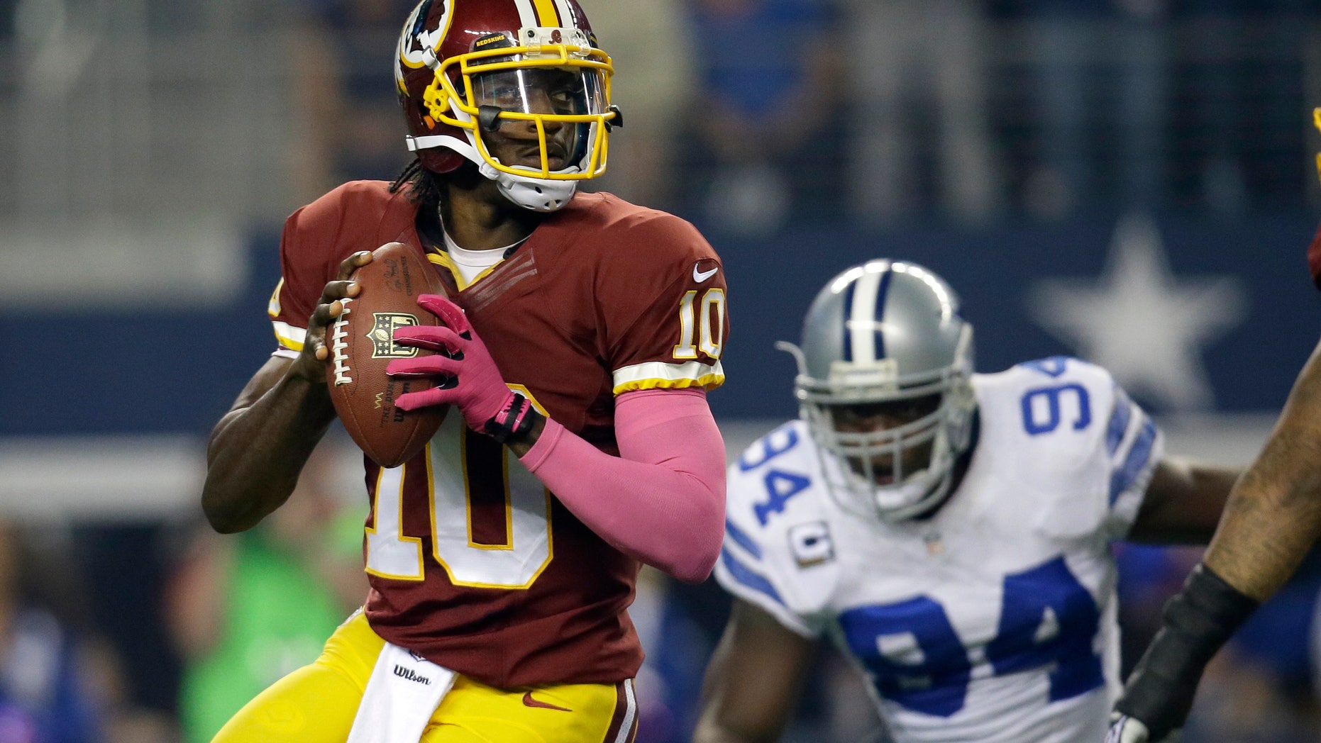 Washington Redskins quarterback Robert Griffin III (10) prepares to pass as Dallas Cowboys defensive end DeMarcus Ware (94) defends in the first half of an NFL football game, Sunday, Oct. 13, 2013, in Arlington, Texas. (AP Photo/Tim Sharp)