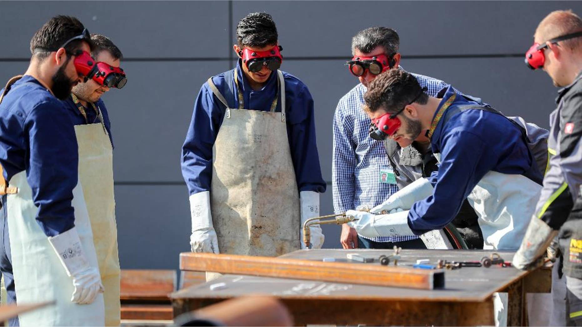 Syrian refugees learning how to reconstruct houses at the education center of the pioneer troop of the German military in Ingolstadt, Germany, Thursday, Sept. 1, 2016. Germany's military is starting a pilot project to help Syrian refugees learn civil reconstruction skills, in hopes that they'll eventually be able to help rebuild their homeland. (Kay Nietfeld/dpa via AP)