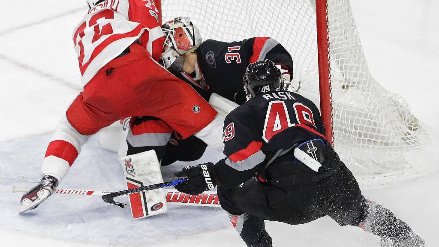 Detroit Red Wings' Andreas Athanasiou (72) collides with Carolina Hurricanes goalie Eddie Lack (31), of Sweden, while scoring the game winning goal during overtime in an NHL hockey game in Raleigh, N.C., Monday, March 27, 2017. Detroit won 4-3. Lack was injured on the play. (AP Photo/Gerry Broome)