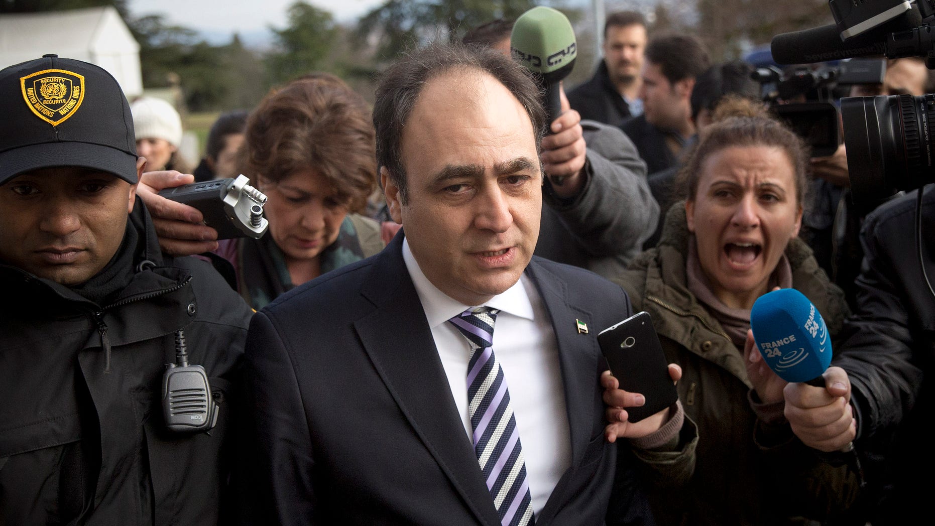 Monzer Akbik, center, a spokesman of the Syrian National Coalition, Syria's main political opposition group, is surrounded by journalists after a meeting with the Syrian government at the United Nations headquarters in Geneva, Switzerland, Sunday, Jan. 26, 2014. Syrians on opposite sides of their country’s civil war tried again Sunday to find common ground, with peace talks focusing on an aid convoy to a besieged city that once more came under mortar attack from the government. (AP Photo/Anja Niedringhaus)