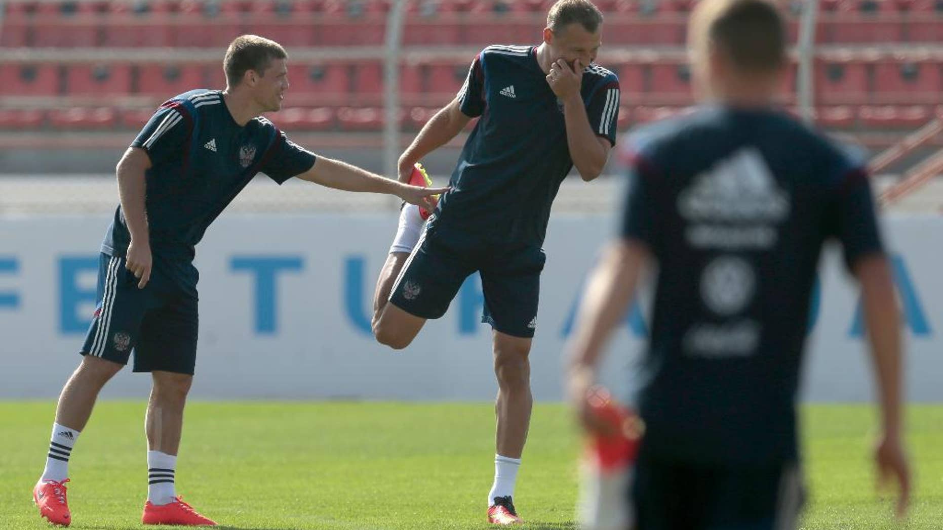 Igor Denisov, left, and Vasily Berezutsky share a joke during the training session of Russian national soccer team in Itu, Brazil, on Sunday, June 15, 2014. Russia will play in group H of the 2014 soccer World Cup. (AP Photo/Ivan Sekretarev)