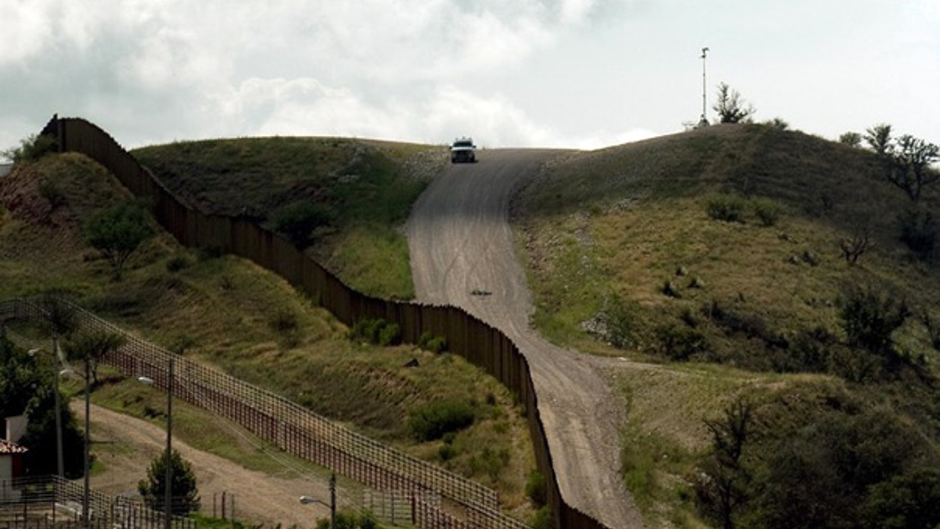 July 28: A U.S. Border Patrol vehicle drives along the fence separating the U.S. from Mexico, near Nogales, Sonora, Mexico.