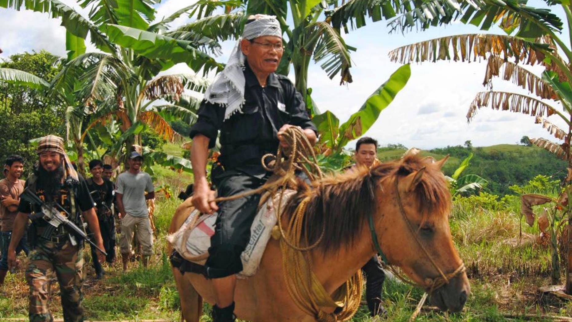 FILE - In this file photo taken Tuesday, Aug. 16, 2011, Ameril Umbra Kato, the commander of the Bangsamoro Islamic Freedom Movement, rides a horse inside his rebel stronghold in Maguindanao province in southern Philippines. The commander whose rebels have pledged support to the Islamic State group died Tuesday following a long ailment, the Philippine military and insurgents said Wednesday, April 15, 2015. (AP Photo/Nickee Butlangan, File)