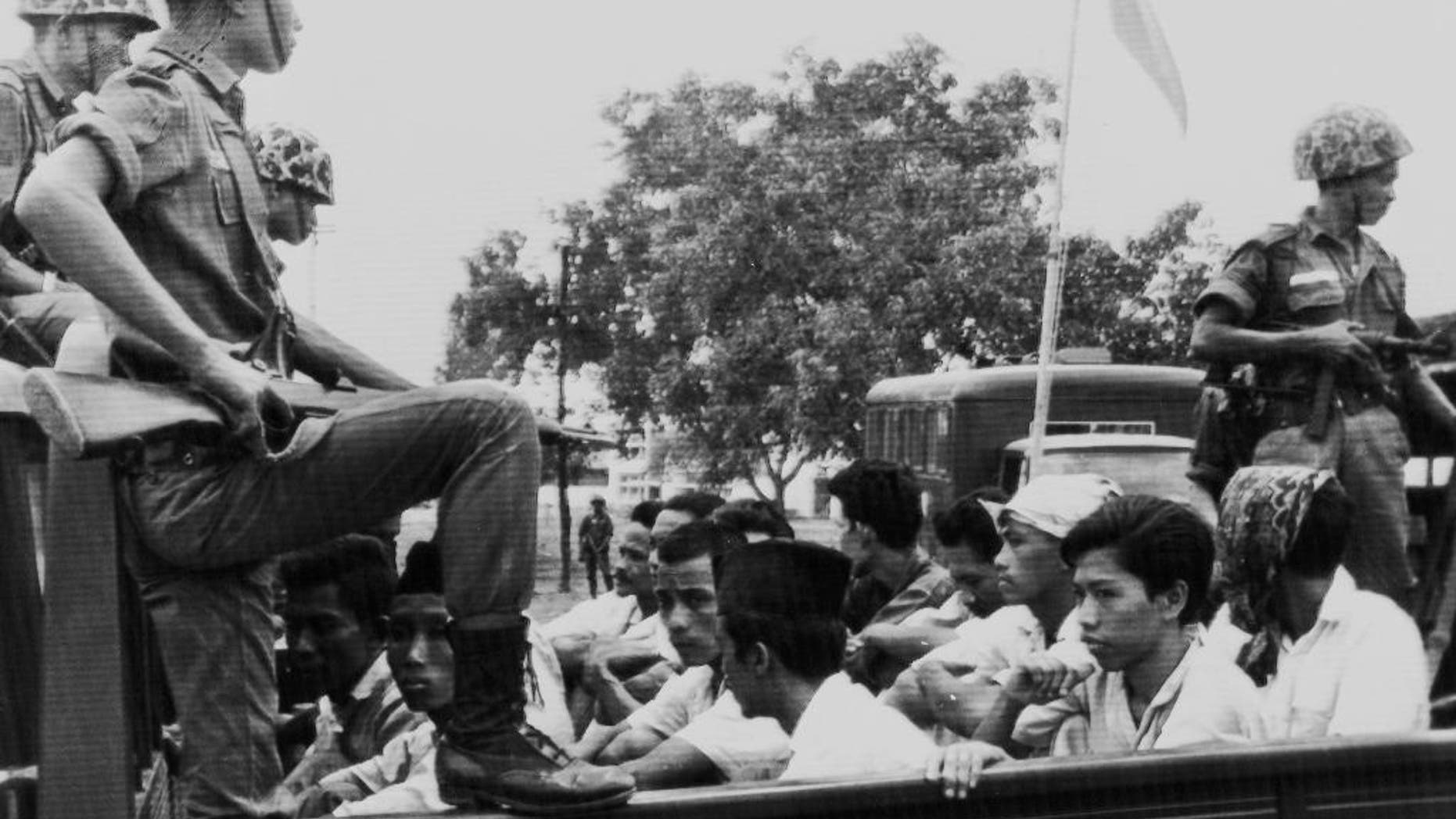 In this Oct. 30, 1965, file photo, members of the Youth Wing of the Indonesian Communist Party (Pemuda Rakjat) are watched by soldiers as they are taken to prison in Jakarta following a crackdown on communists after an abortive coup against President Sukarno's government earlier in the month.