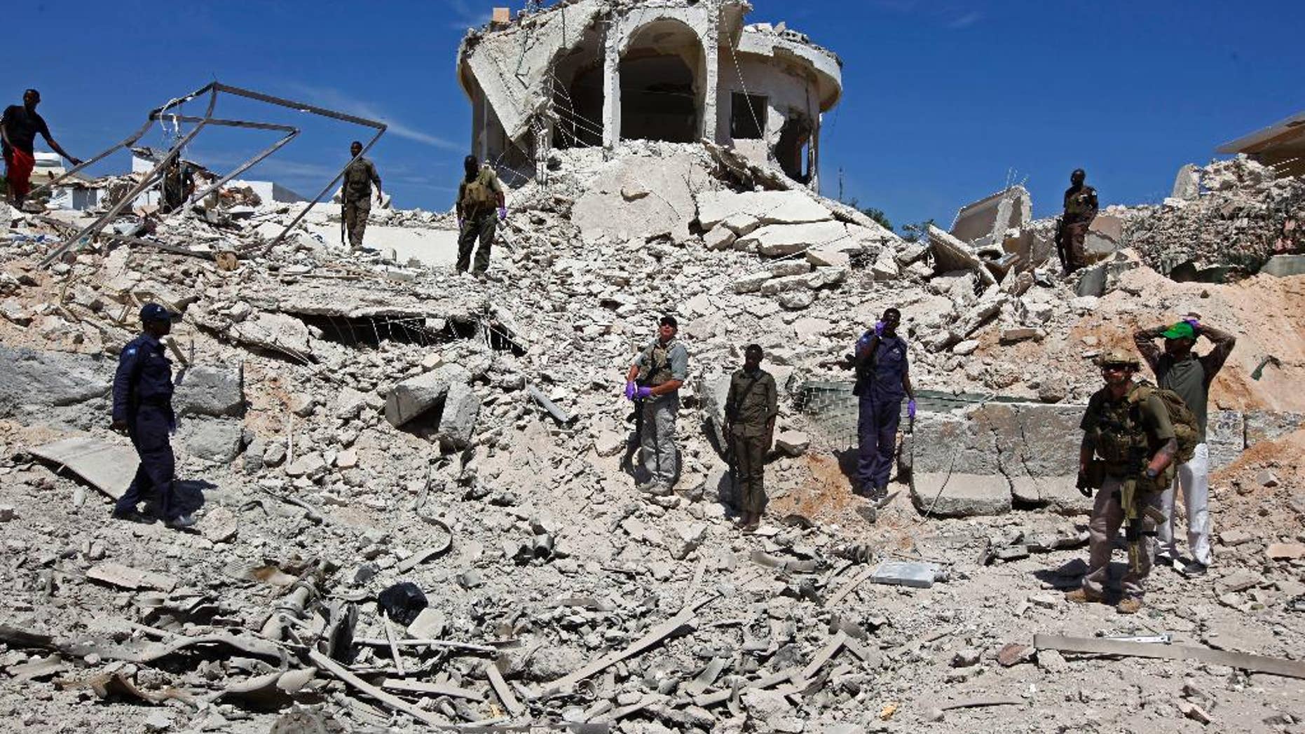 Soldiers stand in the rubble of a destroyed building near the scene of a suicide car bomb attack in Mogadishu, Somalia, Monday, Jan, 2, 2017. An attacker detonated an explosives-laden vehicle at a security checkpoint near Mogadishu's international airport, killing several people, according to a police officer. The assaults have threatened this Horn of Africa nation's attempts to rebuild from decades of chaos. The country's presidential election, a key step toward recovery, already has been delayed multiple times because of security and other concerns. (AP Photo/Farah Abdi Warsameh)