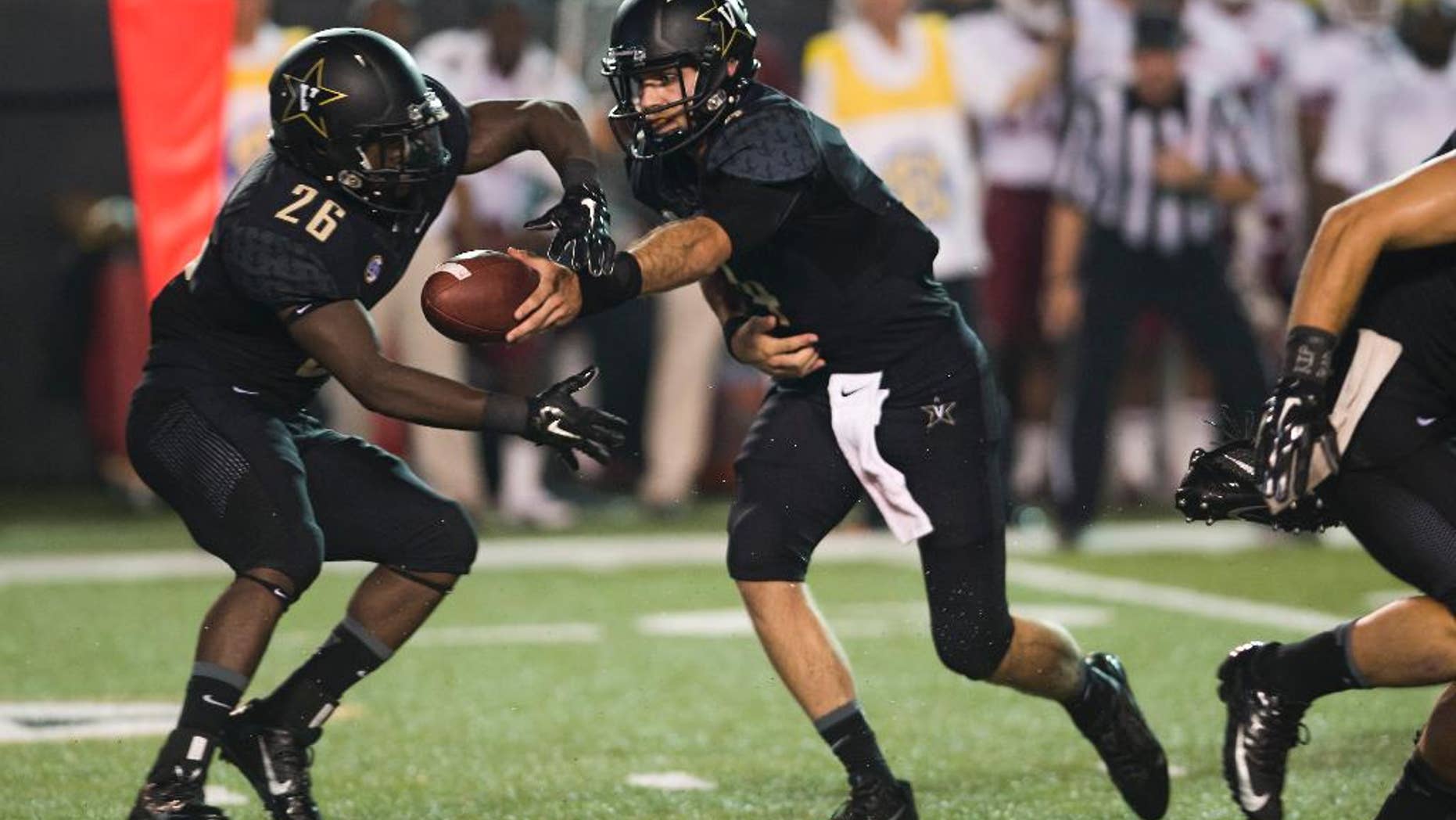 Vanderbilt quarterback Patton Robinette, right, hands off the ball to running back Ralph Webb (26) in the first quarter of an NCAA college football game against Temple on Thursday, Aug. 28, 2014, in Nashville, Tenn. (AP Photo/Brian Powers)