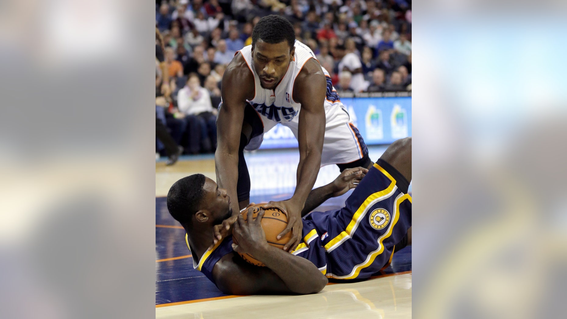 Charlotte Bobcats' Michael Kidd-Gilchrist, top, tries to steal the ball from Indiana Pacers' Lance Stephenson, bottom, during the first half of an NBA basketball game in Charlotte, N.C., Wednesday, Nov. 27, 2013. (AP Photo/Chuck Burton)