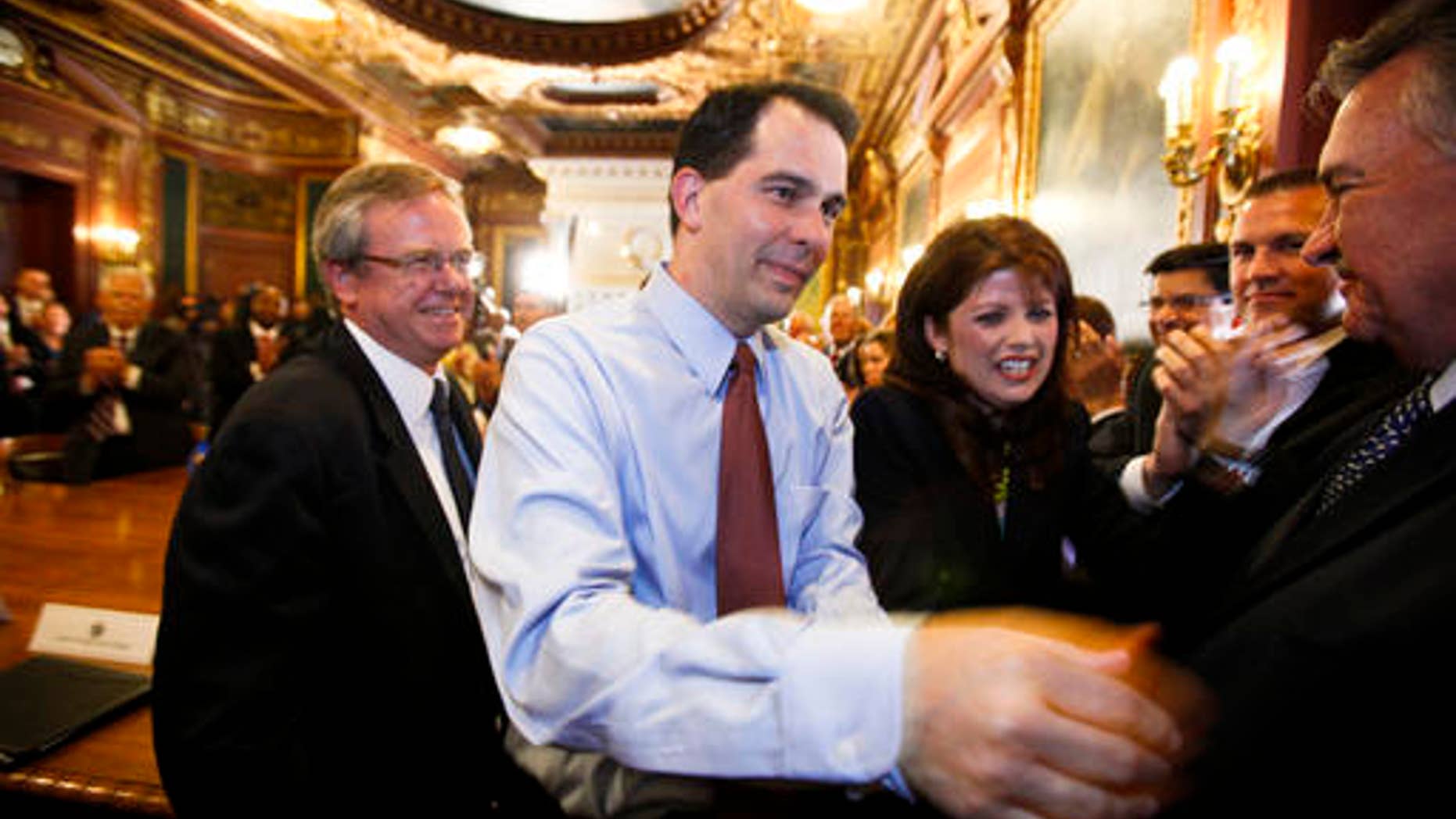 In this June 6, 2012 file photo, Wisconsin Gov. Scott Walker, second from left, and Lt. Gov. Rebecca Kleefisch are greeted by the governor's cabinet and staff at the state Capitol Madison, Wis., a day after Walker beat Milwaukee Mayor Tom Barrett in a recall election. (AP)