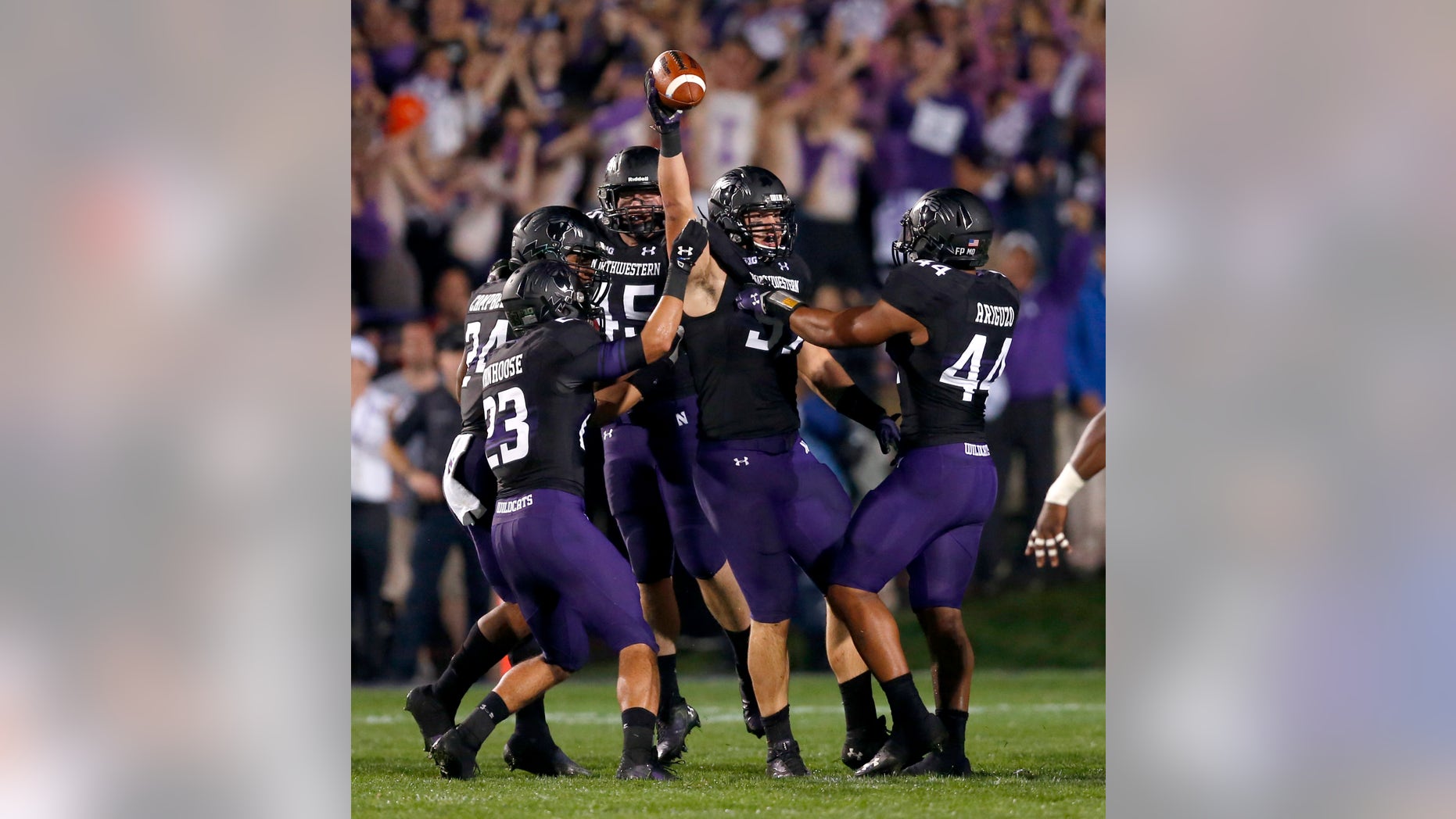 Northwestern defensive lineman Tyler Scott holds the ball up after causing a fumble by Ohio State quarterback Braxton Miller namduring the first half of an NCAA football game Saturday, Oct. 5, 2013, in Evanston, Ill. (AP Photo/Charles Rex Arbogast)