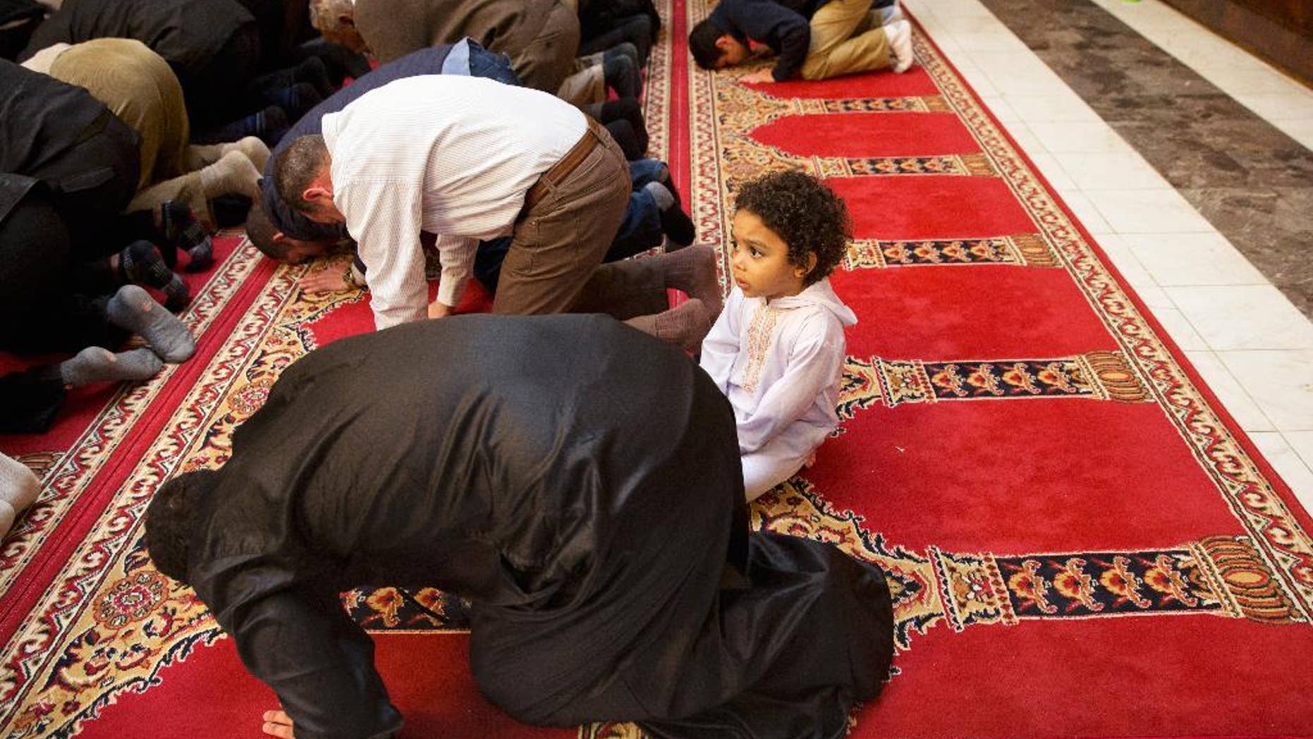 FILE - In this Dec. 4, 2015 file photo, Aiden Abdelaziz, 2, attends prayers with his father, Mohamed Abdelaziz, 22, originally from Cairo, Egypt, at Dar al-Hijrah Mosque in Falls Church, Va. Americans are more likely to say protecting religious liberties of Christians is important than to say the same for Muslims, according to a new poll by The Associated Press and the NORC Center for Public Affairs Research. (AP Photo/Jacquelyn Martin, File)