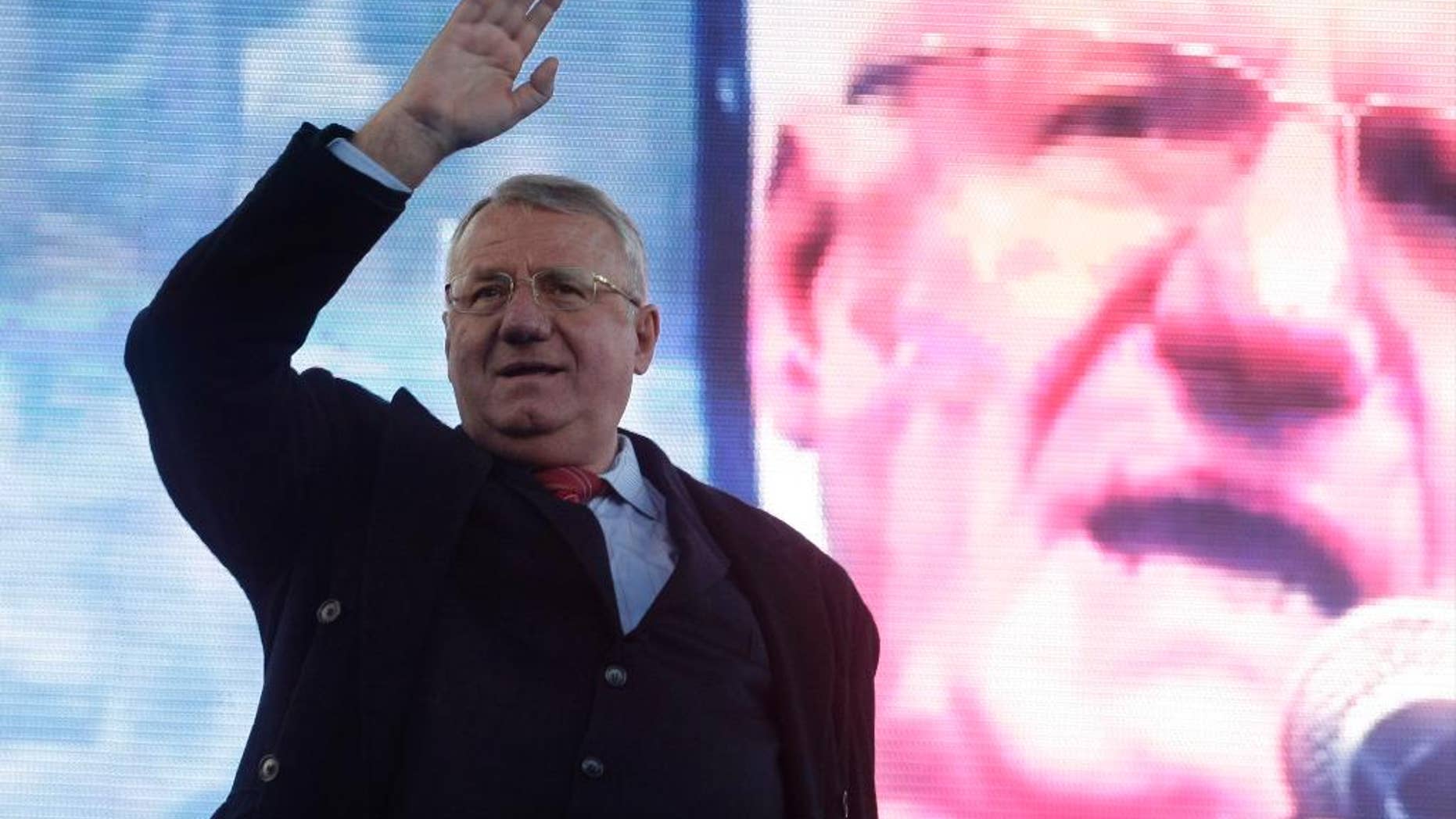 In this Thursday, March 24, 2016 file photo, Serbian ultranationalist and war crimes suspect Vojislav Seselj waves to supporters during a rally in Belgrade, Serbia. The judgment in Seselj's case at the U.N. war crimes court is scheduled for Thursday, March 31. (AP Photo/Andrej Cukic, File)