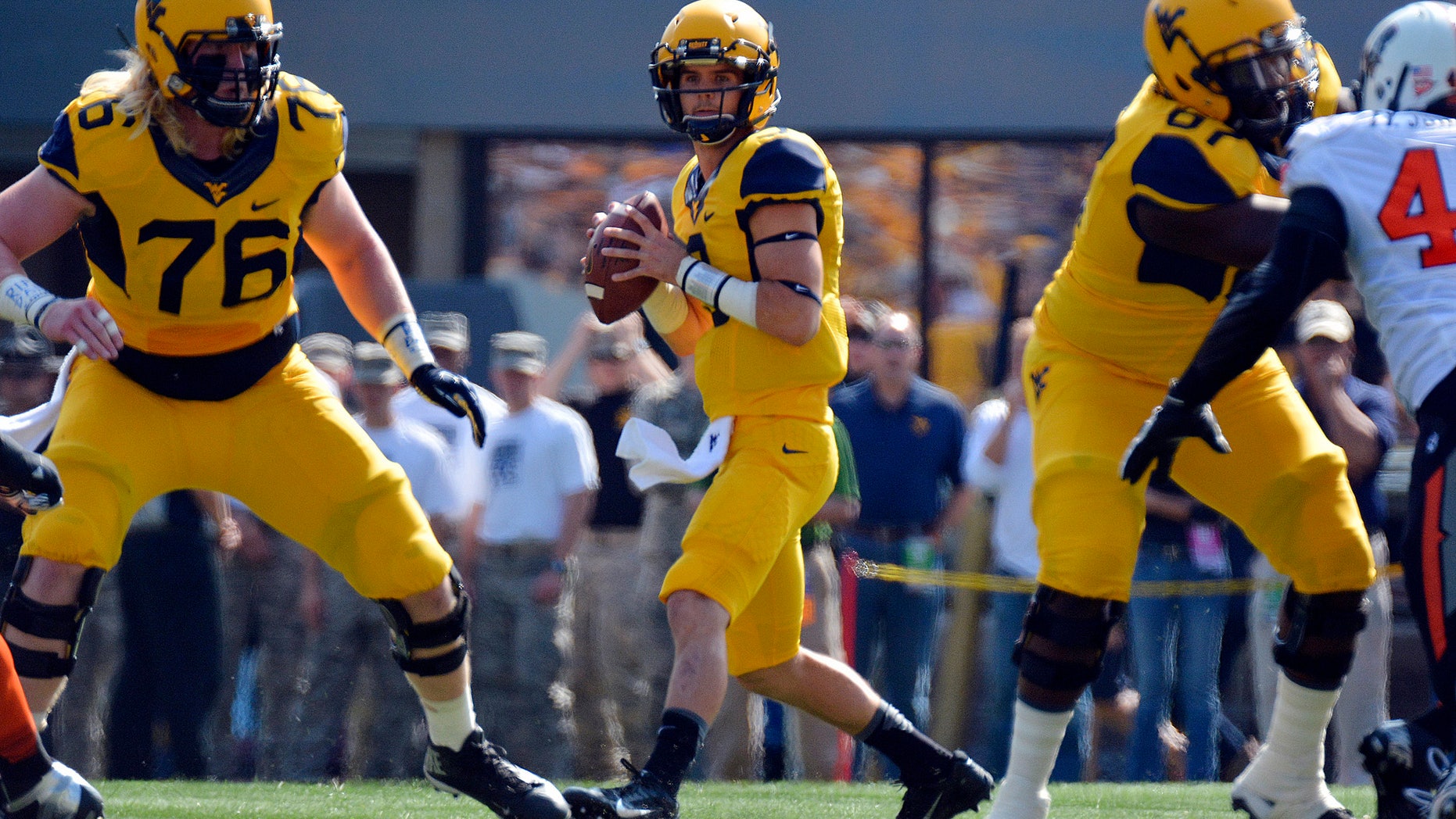 West Virginia quarterback Clint Trickett (9) looks for an open receiver during the first quarter of an NCAA college football game against Oklahoma State in Morgantown, W.Va., on Saturday, Sept. 28, 2013. (AP Photo/Tyler Evert)