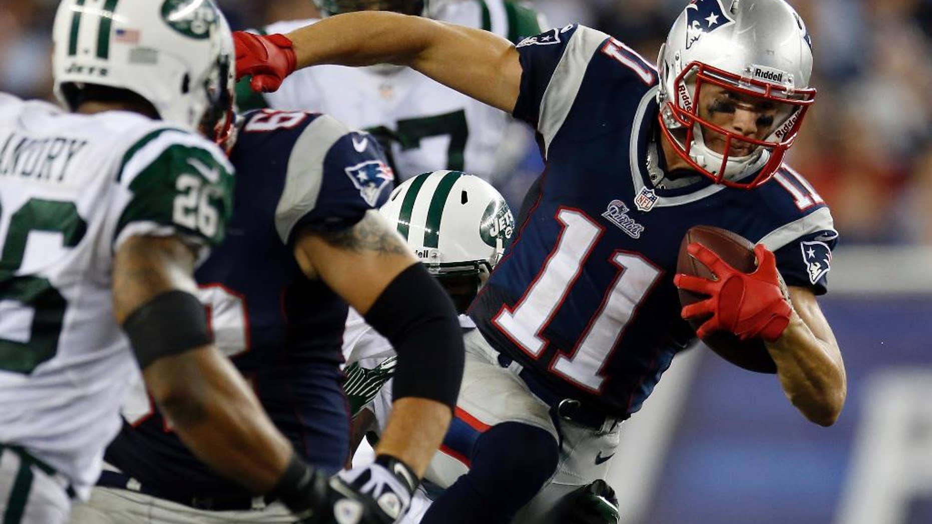 FILE - In this Sept. 13, 2013, file photo, New England Patriots wide receiver Julian Edelman (11) runs past New York Jets strong safety Dawan Landry (26) during the second quarter of an NFL football game in Foxborough, Mass. Edelman surprisingly emerged as the Patriots top receiver last season. And he says he won't change just because he signed a big contract in the offseason. (AP Photo/Elise Amendola, File)