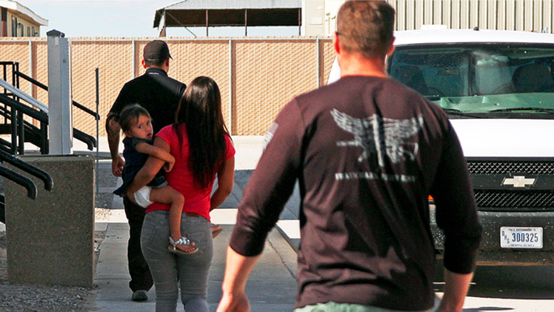 A woman and child are escorted to a van by detention facility guards inside the Artesia Family Residential Center, a federal detention facility for illegal immigrants and children in Artesia, N.M. (AP Photo/Juan Carlos Llorca, File)