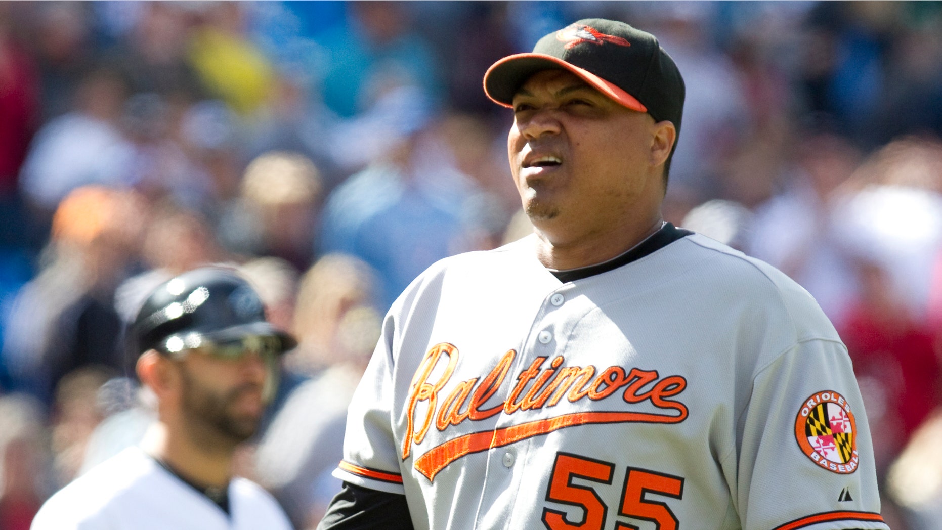 FILE - In this Sept. 26, 2010 file photo, Baltimore Orioles pitcher Alfredo Simon, right, walks off the field after being ejected from the game by home plate umpire Bill Welke after striking Toronto Blue Jays batter Jose Bautista, background left, with a ball during fifth-inning baseball game action in Toronto. Police say Baltimore Orioles pitcher Alfredo Simon is the main suspect in the fatal shooting of a man in the Dominican Republic. Dominican police said in a statement Sunday, Jan. 2, 2011 they believe Simon shot and killed 25-year-old Michel Castillo Almonte and wounded his 17-year-old brother during a New Year's Eve dispute in the northeast coastal town of Luperon. (AP Photo/The Canadian Press, Chris Young)