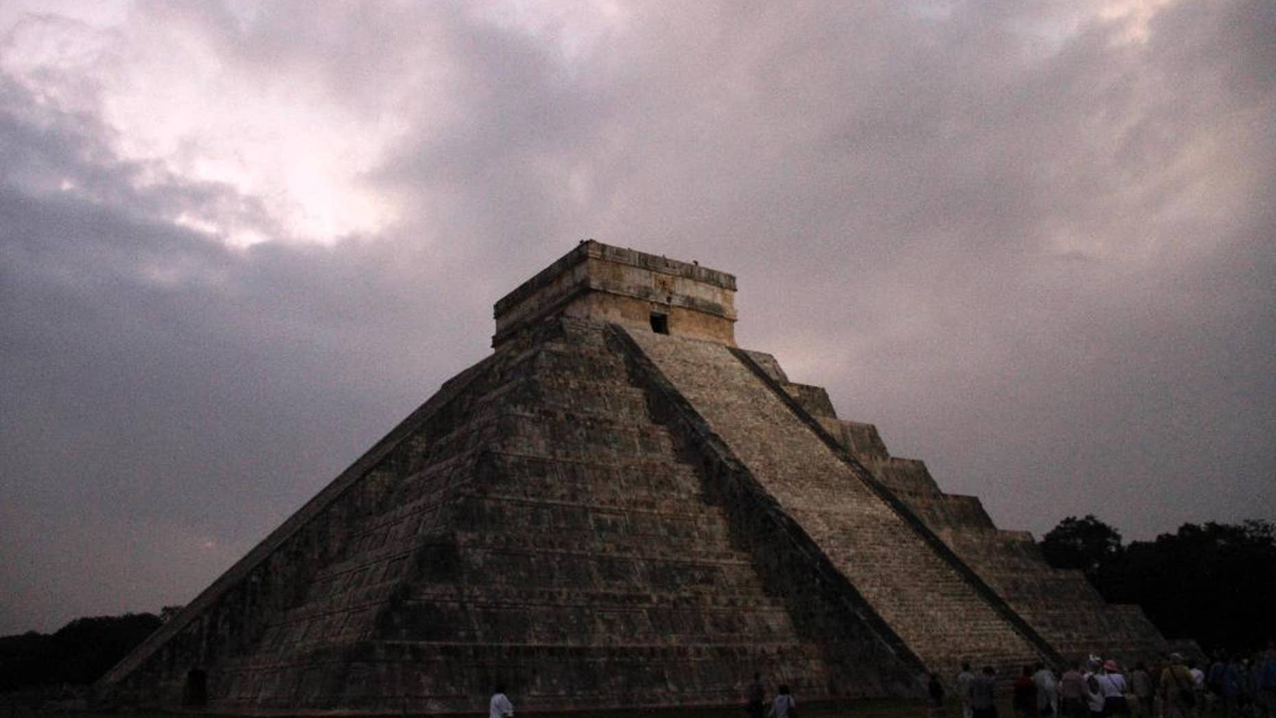 FILE - In this Dec. 21, 2012 file photo, people gather in front of the Kukulkan temple in Chichen Itza, Mexico. Mexican experts said Wednesday, Nov. 16, 2016 they have discovered what may be the original structure at the pyramid of Kukulkan at the Mayan ruins of Chichen Itza. (AP Photo/Israel Leal, File)