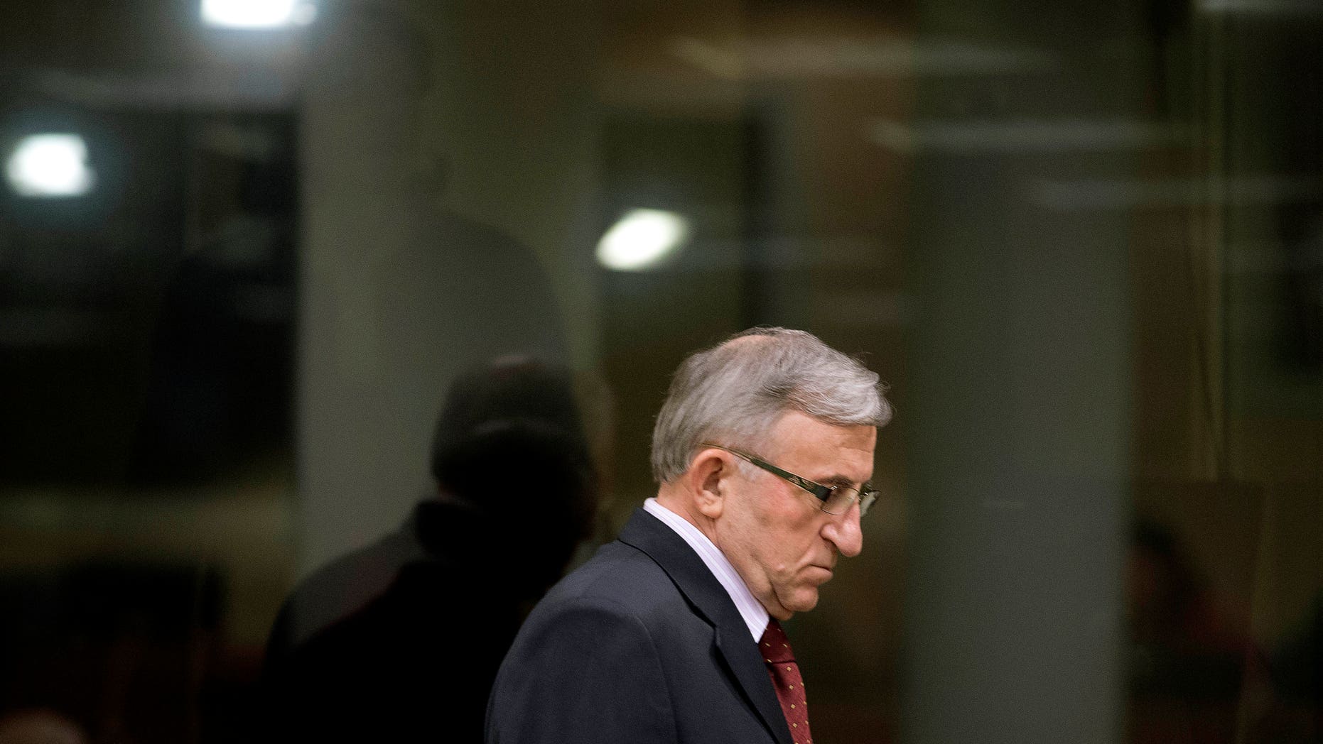Vladimir Lazarevic enters the Yugoslav war crimes tribunal courtroom in The Hague Thursday, Jan. 23, 2014. Nikola Sainovic, Nebojsa Pavkovic, Sreten Lukic, and Vladimir Lazarevic, four former high-ranking Yugoslav and Serbian political, military and police officials who were convicted in 2009 for crimes committed against Kosovo Albanians in 1999 during Serbia’s deadly crackdown on ethnic Albanians appeared in court at the Yugoslav war crimes tribunal ahead of a decision in their appeal. (AP Photo/Peter Dejong, Pool)